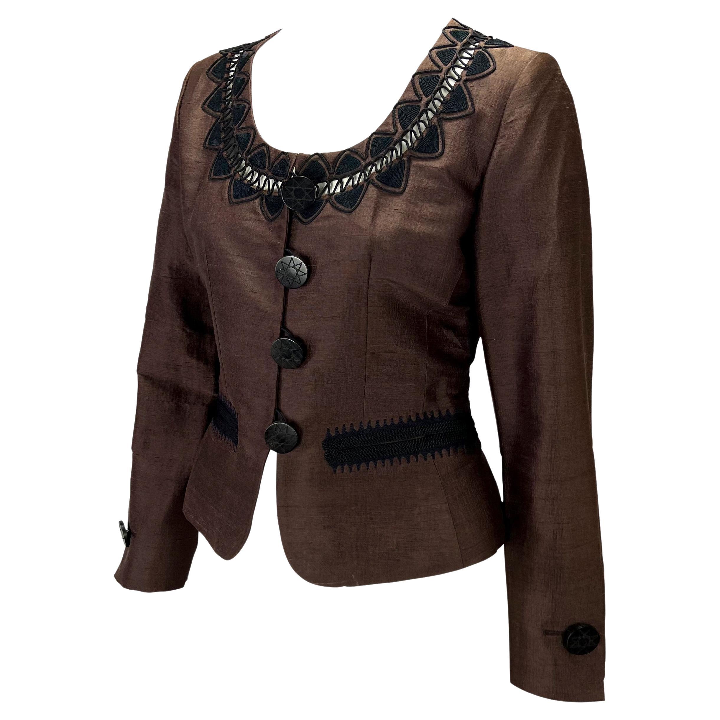 Presenting a brown Yves Saint Laurent Rive Gauche blazer. From the 1995 Cruise collection, this blazer features a scoop neckline, black embroidered details at the neckline and front pockets, and large carved buttons. 

Approximate measurements:
Size