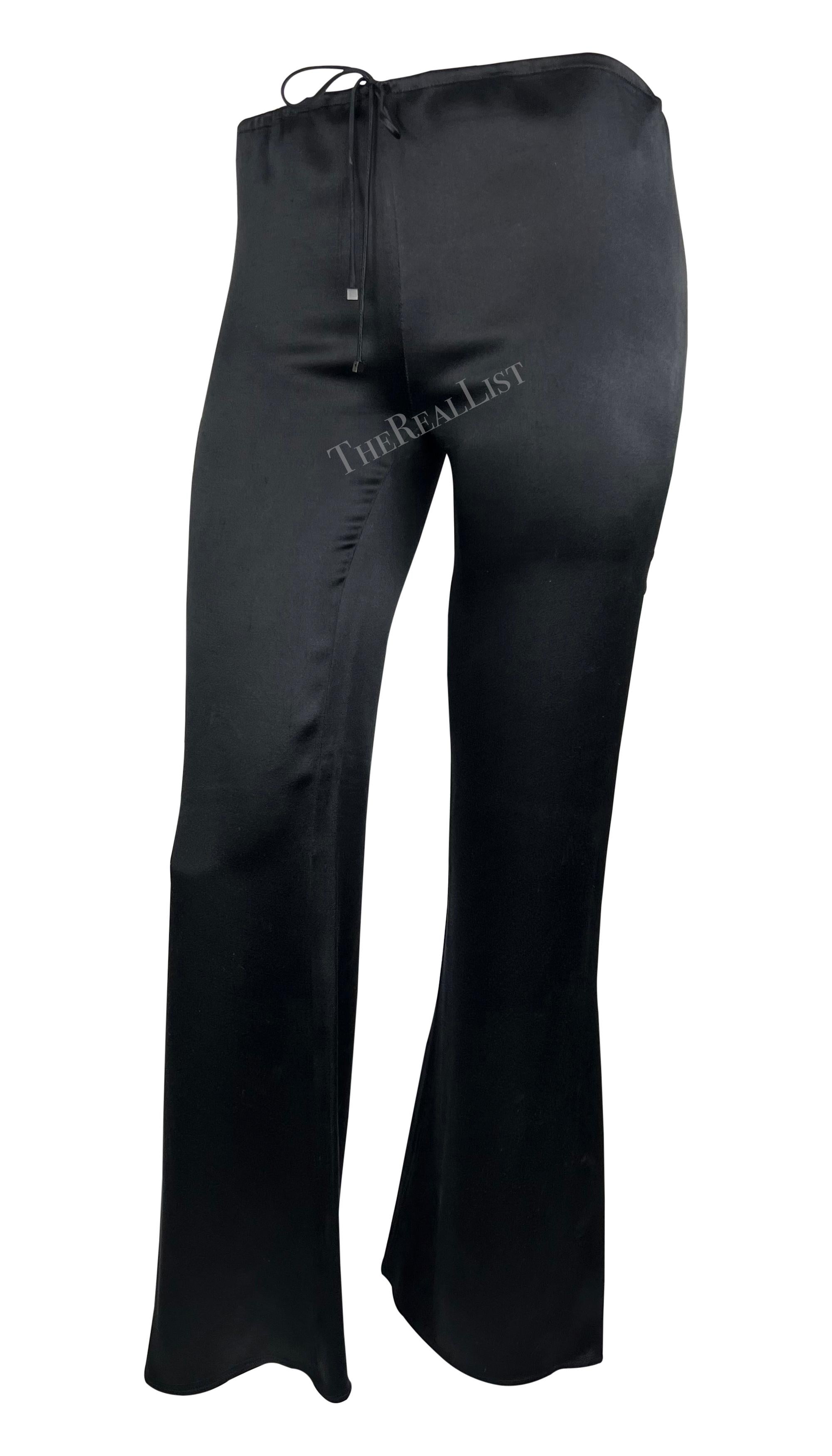 Crafted entirely from soft black silk, these drawstring pants by Gucci, designed by Tom Ford, are from the Cruise 2000 collection. Featuring a flattering flare-cut design, they are a must-have elevated essential. 

Approximate measurements:
Size -