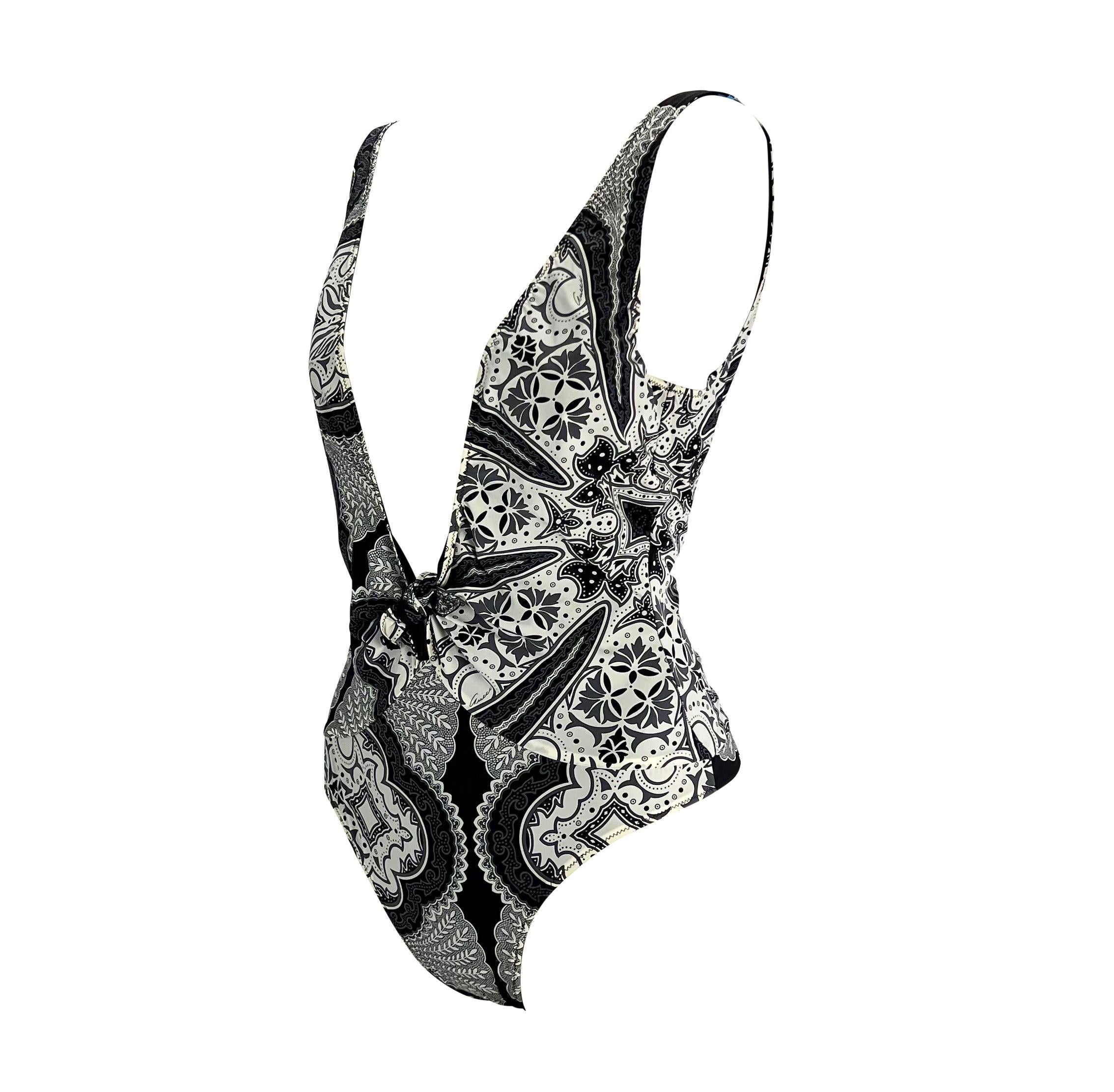 Presenting a black bandana print one piece thong Gucci swimsuit, designed by Tom Ford. From the 2004 cruise collection, this ultra sexy one piece features a plunging neckline with a small bow as well as a low exposed back. This piece in Tom Ford's