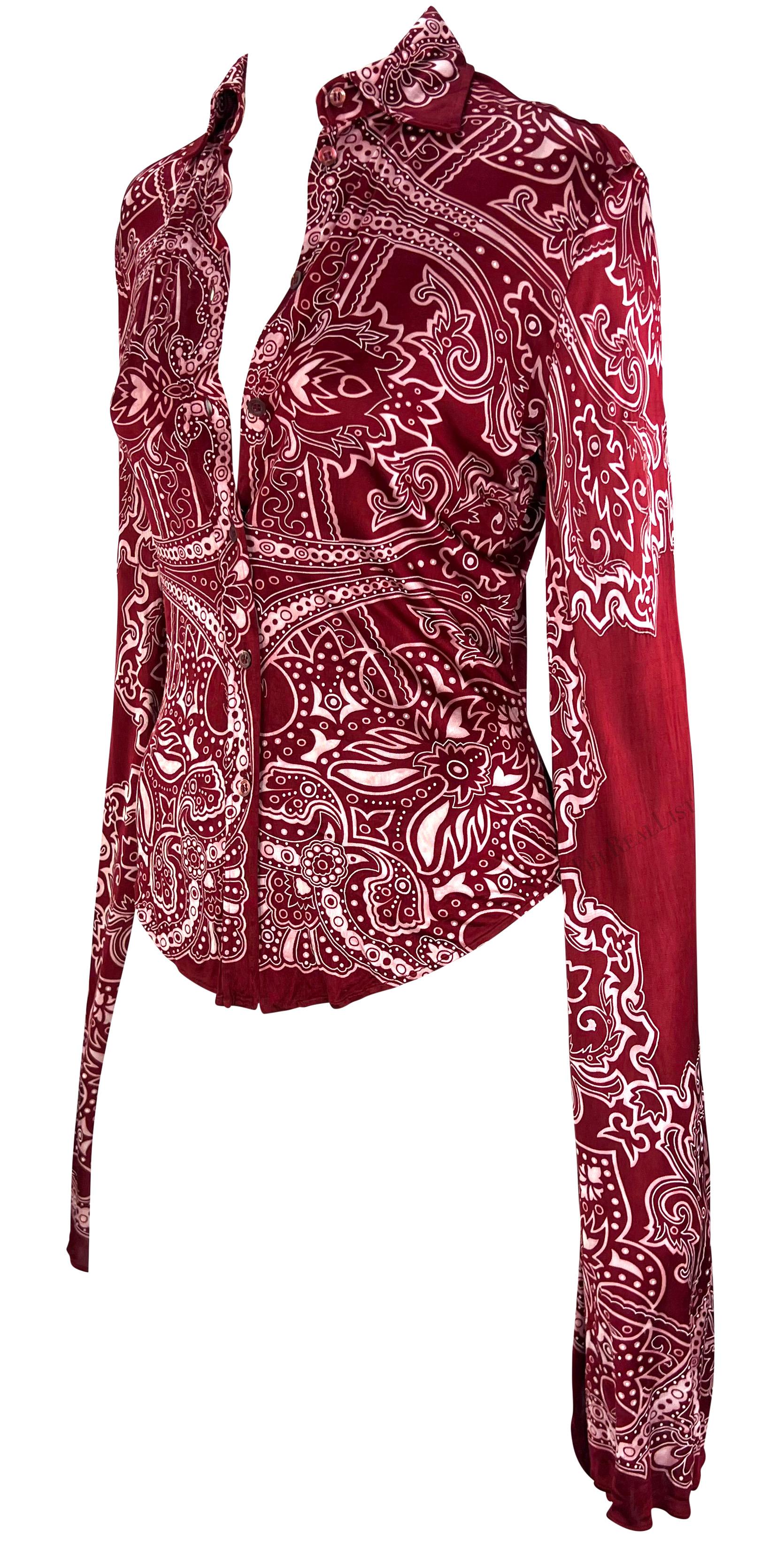 TheRealList presents: a chic red paisley Gucci button-down shirt, designed by Tom Ford. From the 2004 cruise collection, this viscose button-down top is covered in a bold red paisley print. Featuring a fold-over collar and button closure, this top