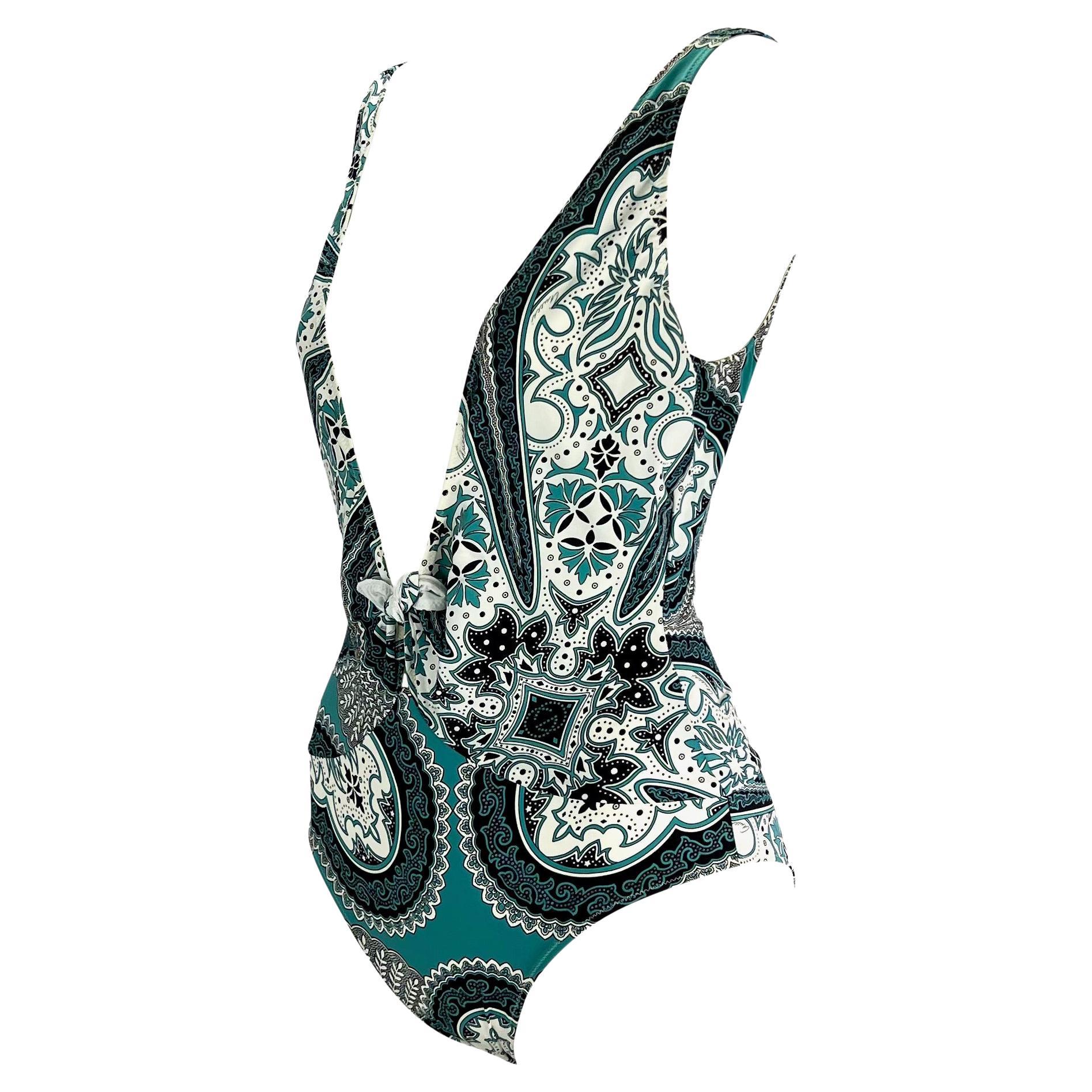 Presenting a blue bandana-print one-piece Gucci swimsuit designed by Tom Ford. From the 2004 cruise collection, this ultra-sexy one-piece features a plunging neckline, a small tie, and a low-exposed back. Nearly 20 years old and still brand new with