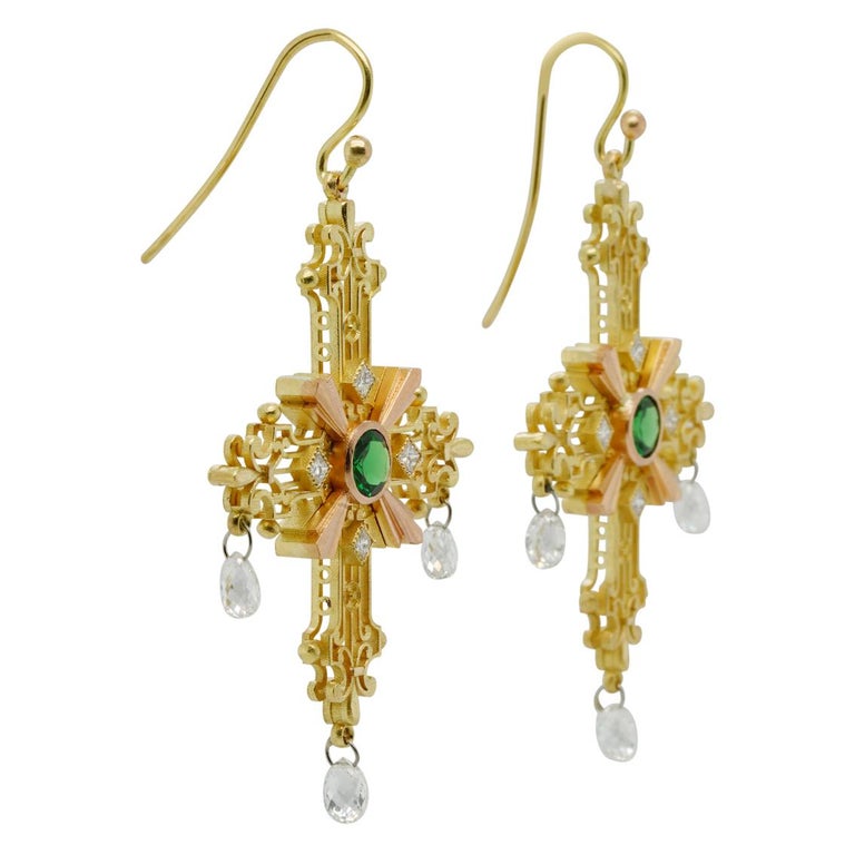 The Crux Gemmata (latin for jewelled cross) earrings are pure opulence for your ears. 

Beautifully handcrafted in 18kt yellow gold, each cross is delicately formed with scrolls and fleurs de lis resembling fine open filigree work. Striking 18kt