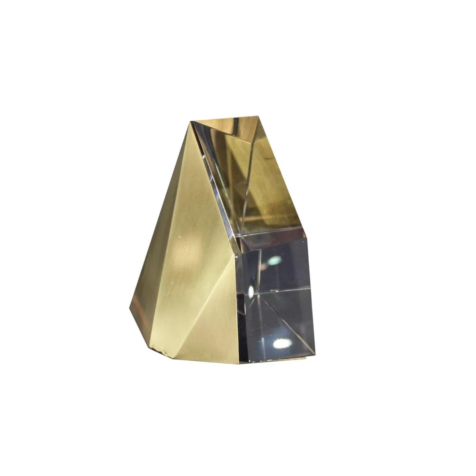 Crystal and Brass Bookend by Dainte
Dimensions: D 19 x W 18 x H 15 cm.
Materials: Crystal and brass.

The multifaceted triangular bookend is brilliantly designed with light-bending clear crystal complemented by shiny metallic brass accents.