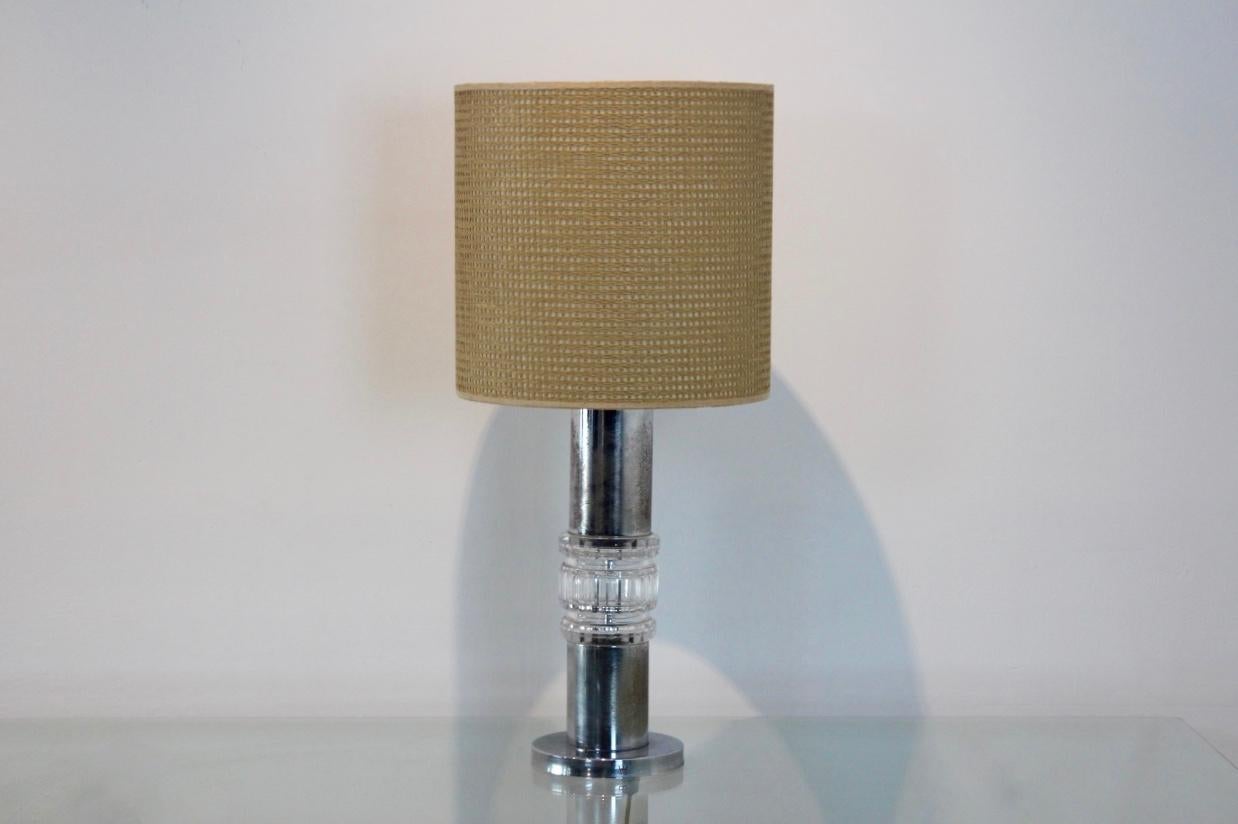 Exceptionnelle lampe de table en chrome et cristal taillé de Kosta Boda, Suède, années 1960 (signée avec une étiquette). Cette lampe est livrée avec l'abat-jour et le diffuseur en raphia d'origine. En raison de la nature antique de ce luminaire, le