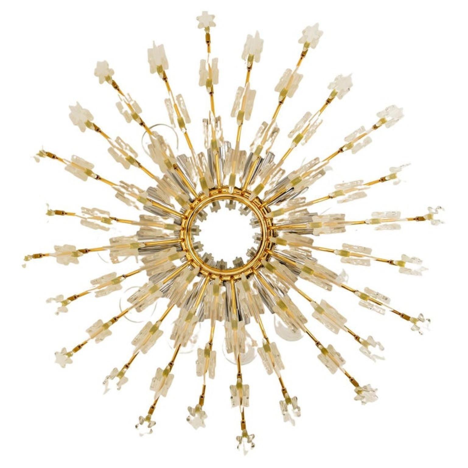 High-end gilded brass flush mount by Stilkronen, made in Italy, circa 1975, featuring a sunburst array of branches holding 30 clear crystals pieces. The crystals refract light beautifully and are perfect for a soft, warm and welcoming glow in the
