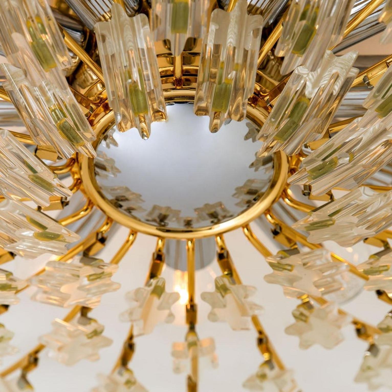 Hochwertige Unterputzdose aus vergoldetem Messing von Stilkronen, hergestellt in Italien, um 1975, mit einer Reihe von Zweigen mit Sonnenschliff, die 30 klare Kristalle tragen. Die Kristalle brechen das Licht wunderschön und sorgen für ein weiches,