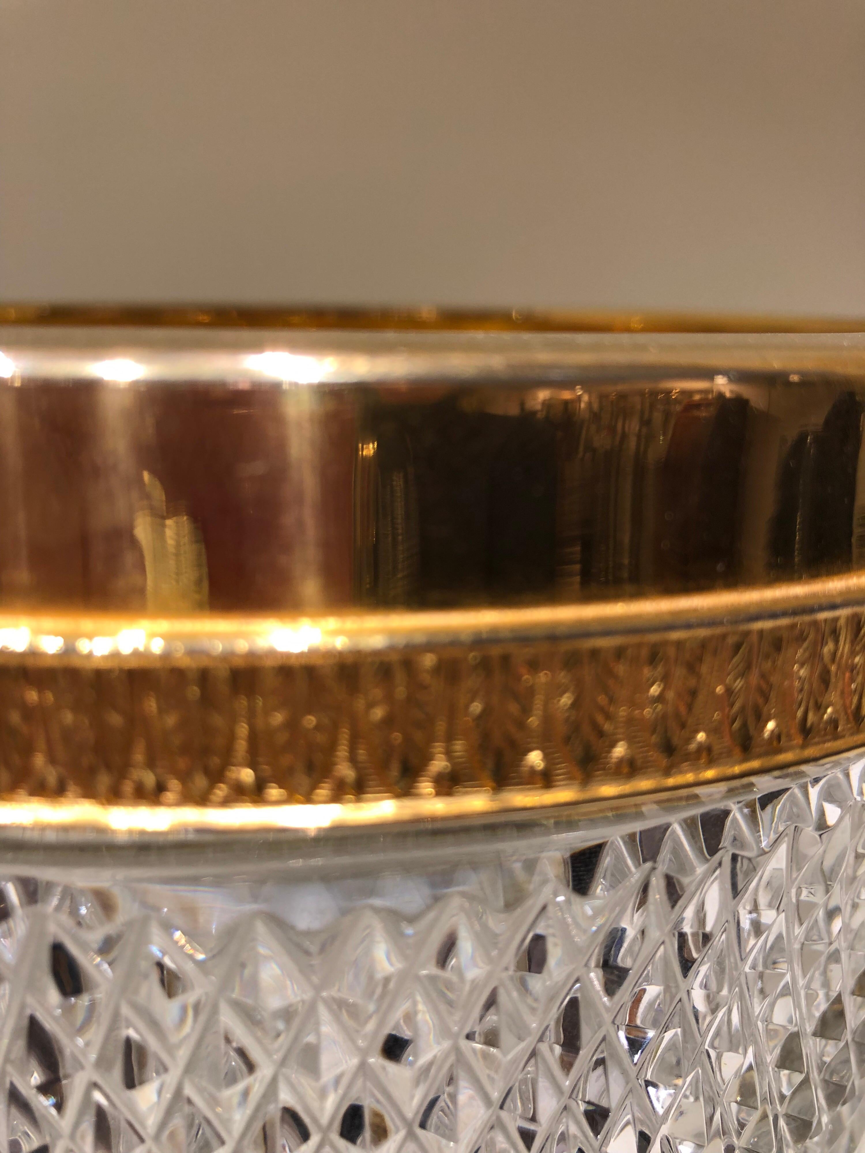 A stunning large and heavy cut crystal ice bucket with gold plating to the rim.