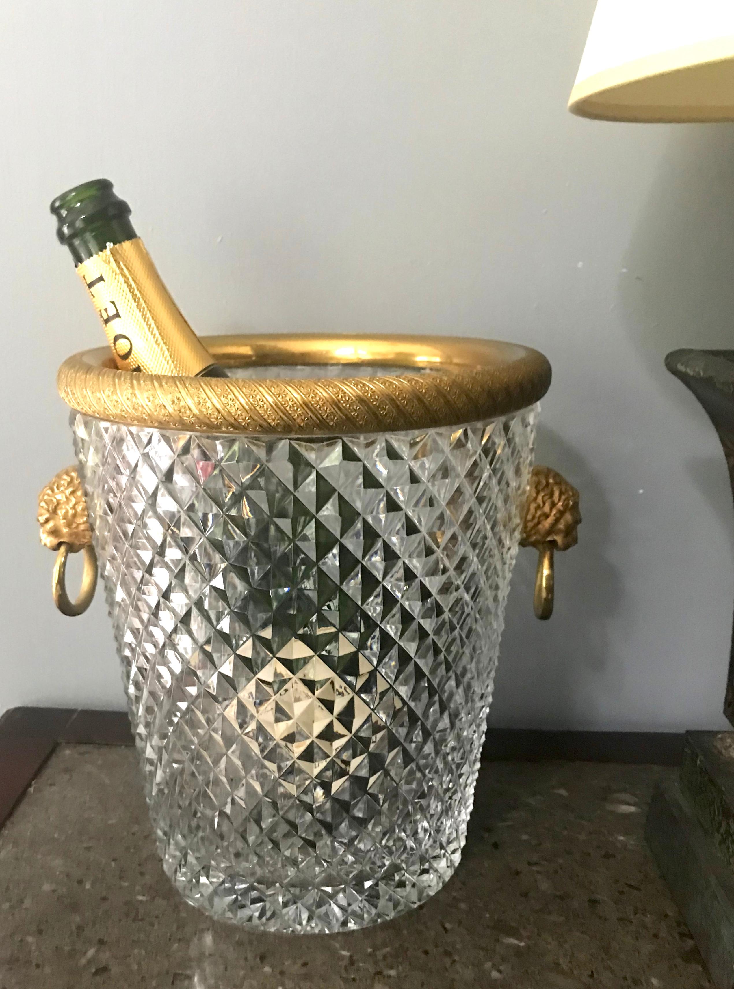 Crystal and ormolu lion head ring-handle champagne ice bucket. Elegant diapered crystal basin with gilt rim and finely chased lion ring handles perfect for chilling Sancerre or champagne or filled with ice for drinks on the porch. In very near