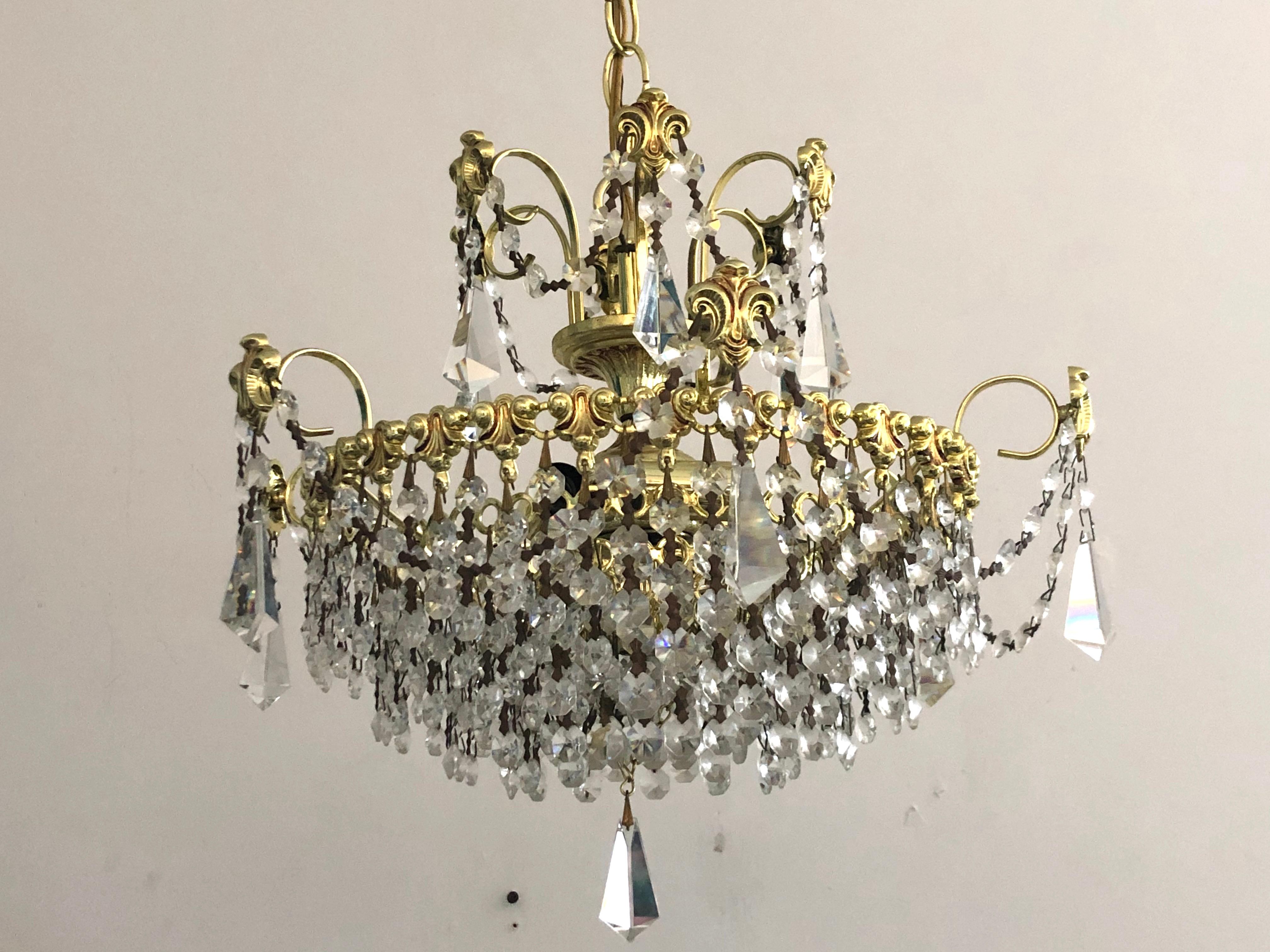 Lampadario vintage degli anni '60 in stile Hollywood Regency con cristalli, perline nere sfaccettate e ottone lucido proveniente da una proprietà di Palm Beach.

5 luci - 4 cerchi in alto, uno rivolto verso il basso dal centro in alto 

Misure:
Il