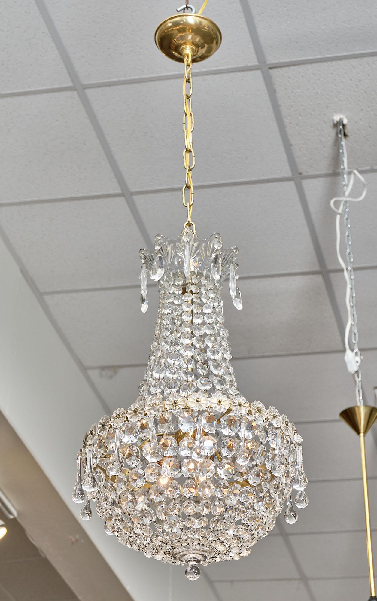 Chandelier from France by Baccarat. The fixture features multiple strands of cut crystal and teardrop pendants. It has been newly wired to fit US standards. The current ceiling height is 46.25