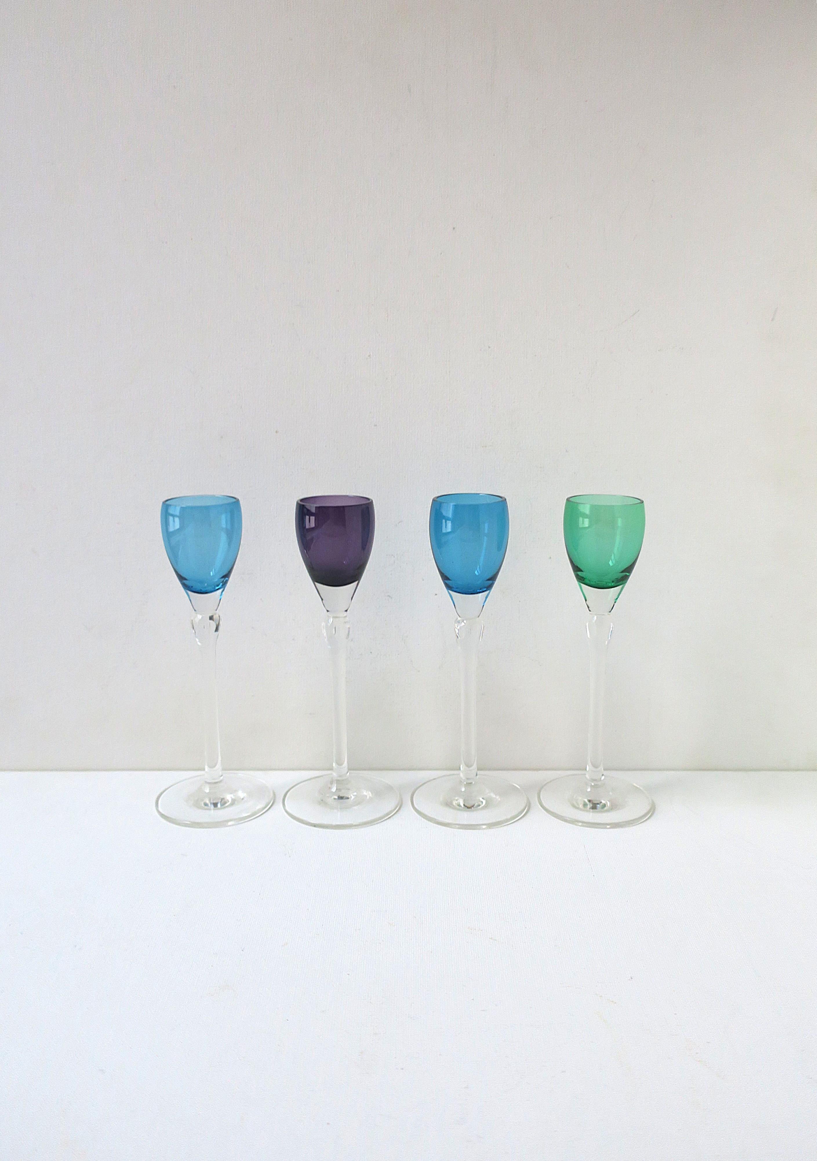 A beautiful set of four (4) colorful crystal aperitif or cordial glasses with teardrop cut design, circa mid-20th century. Colors include two (2) blue, one (1) purple/eggplant and one (1) emerald green. Small teardrop cut design below colored glass