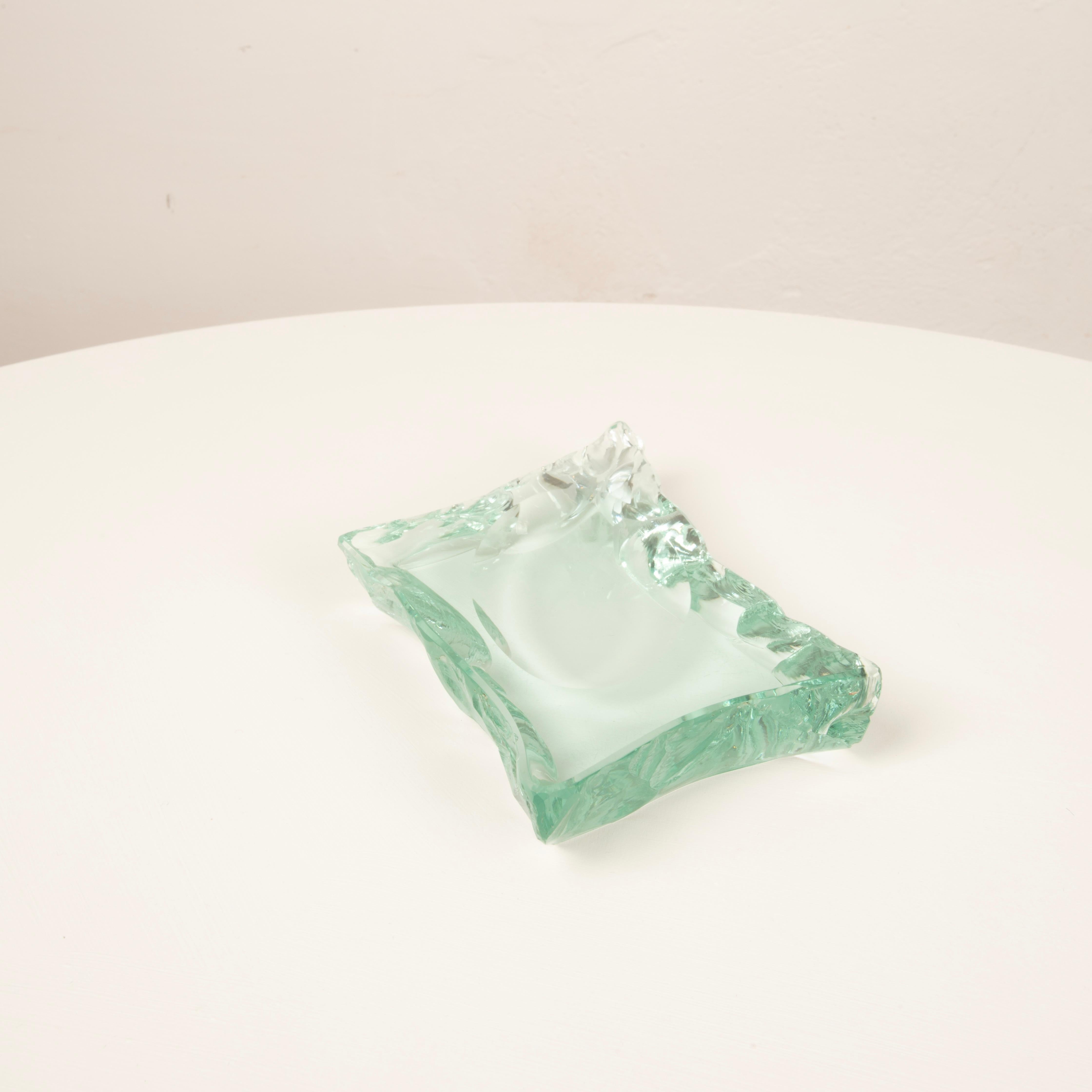 Dieser außergewöhnliche Aschenbecher aus massivem Kristall, der in den 1950er Jahren in Italien von der renommierten Manufaktur Fontana Arte hergestellt wurde, ist eines der emblematischsten Beispiele für die technische Meisterschaft und die