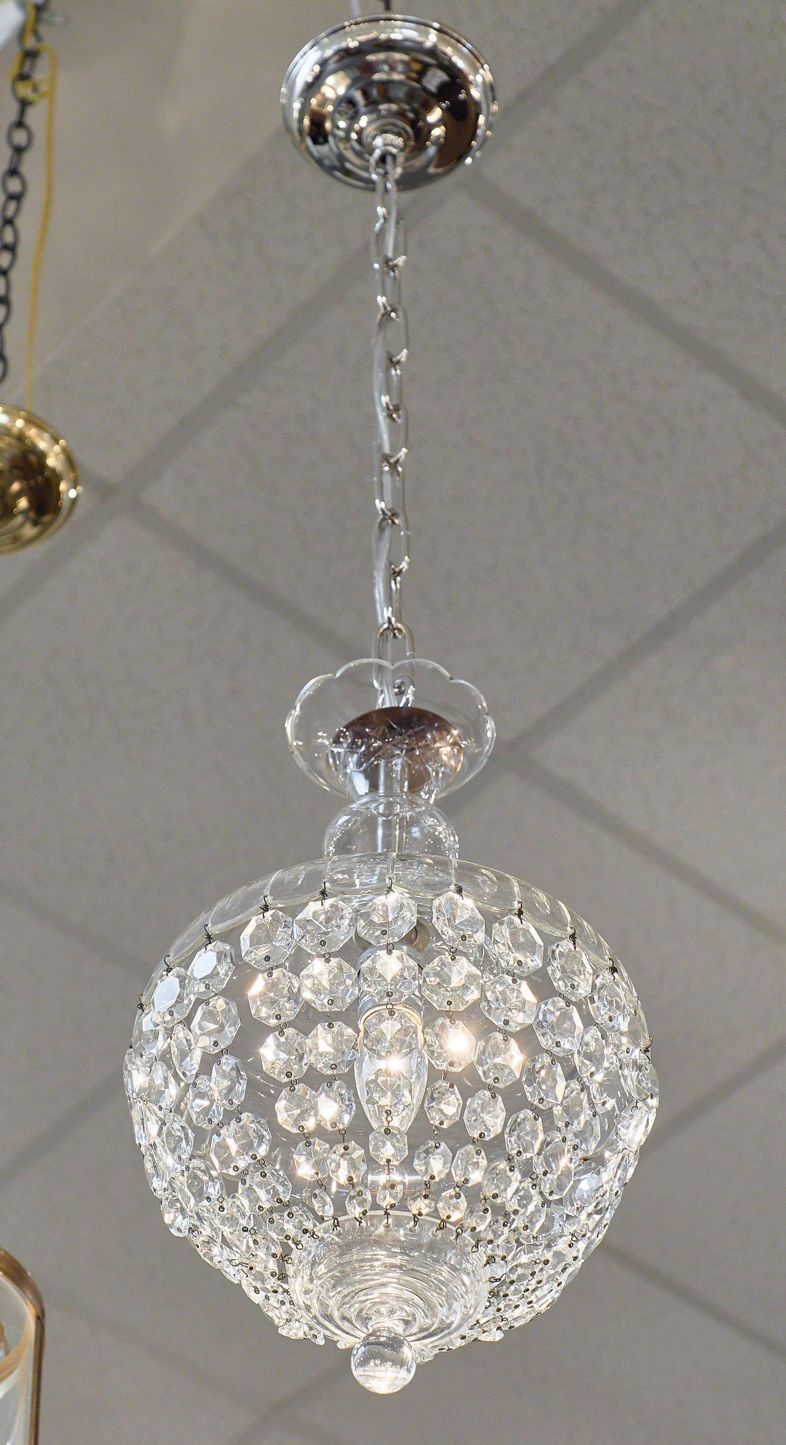French antique crystal Baccarat chandelier of multiple strands of cut crystal “cabochons” connected to a crystal bell. We loved the sparkle down to the bottom finial, the crystal is the best quality you can find. This fixture requires one