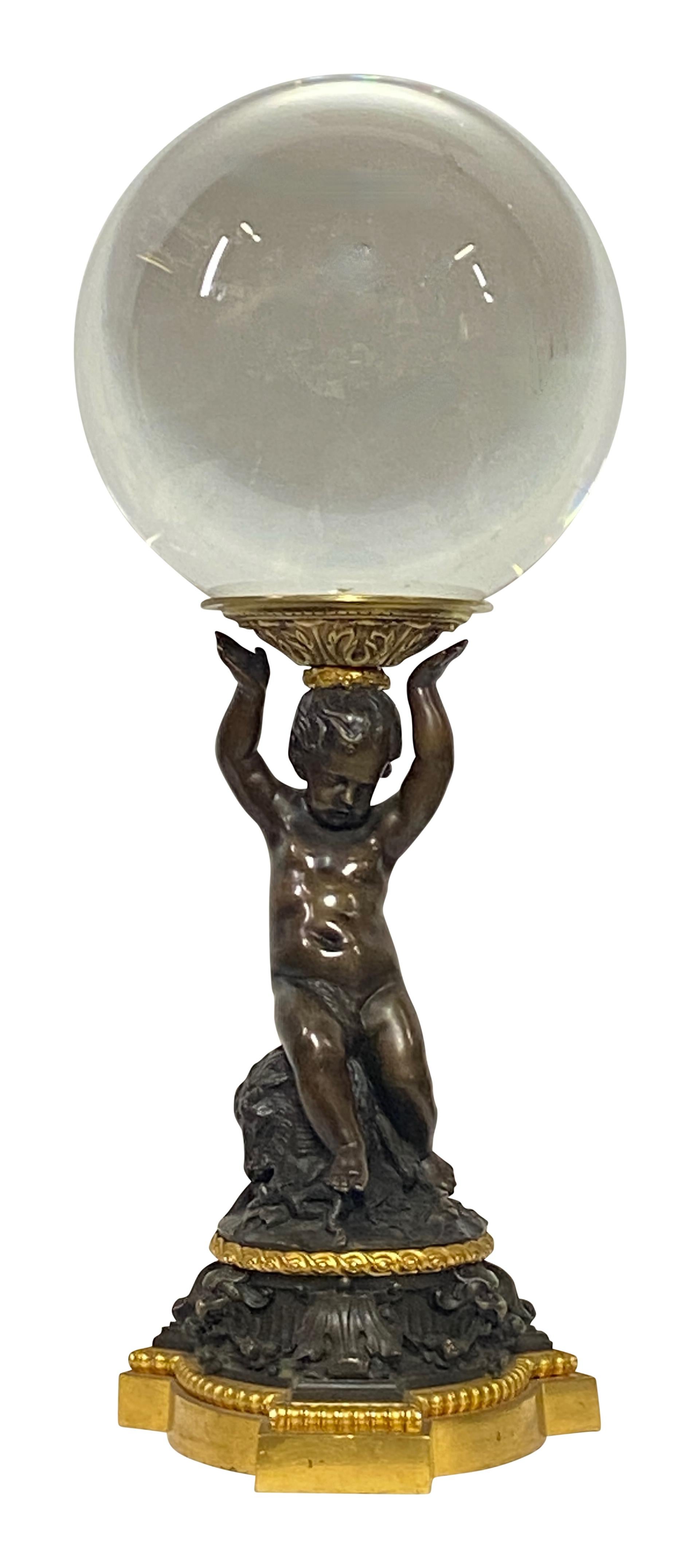 An exceptional Renaissance style patinated and gilt bronze cherub base made in the early to mid 19th century. The figure holding a 10 inch diameter crystal ball.  
Beautiful quality and detail.