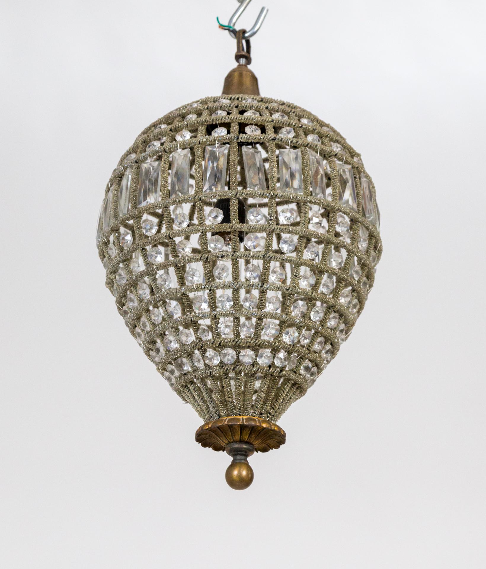 A handmade, upside down teardrop pendant with a frame completely covered in hand-sewn, metallic threads with inset crystal beads and prisms, French, 1940s. Measures: 21