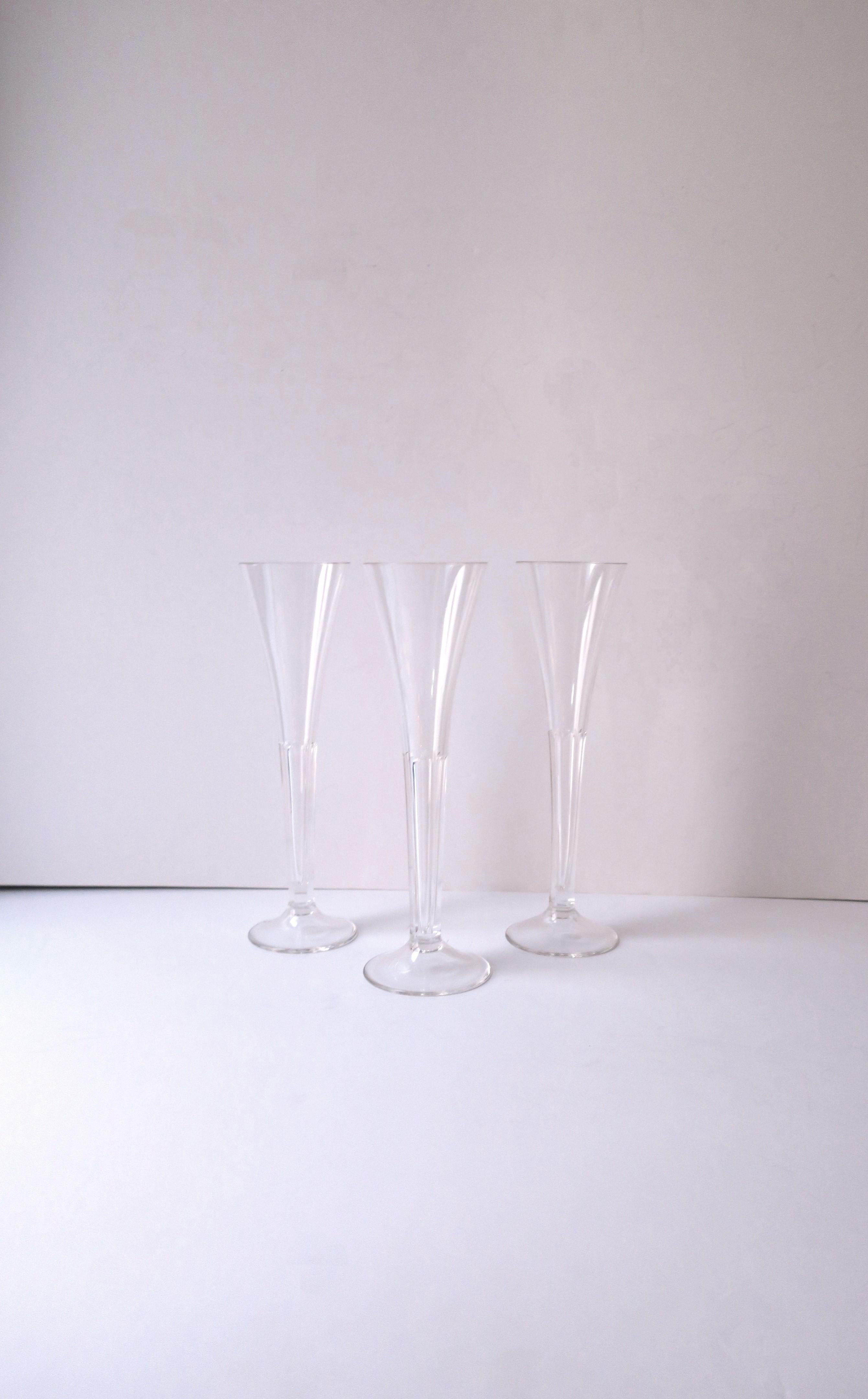 A beautiful set of three (3) crystal Champagne flutes glasses, in the style of Val Saint Lambert, circa mid-20th century, Europe. Designed with a trumpet flute and beautiful smooth cut crystal stem. Very Good condition as shown in images and video.