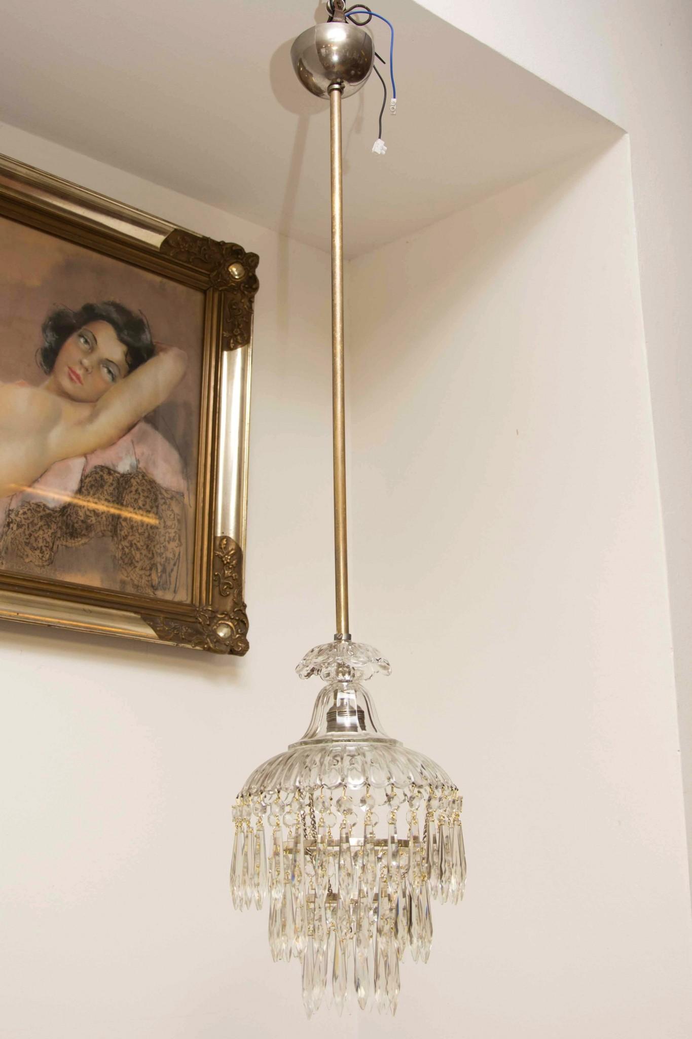 This crystal chandelier was made in the 1940s in the former Czechoslovakia. It has a new wiring. An excellent quality piece, it has a cut glass beads and pendants hanging from the brass centre. In very good Vintage condition, consistent with age and
