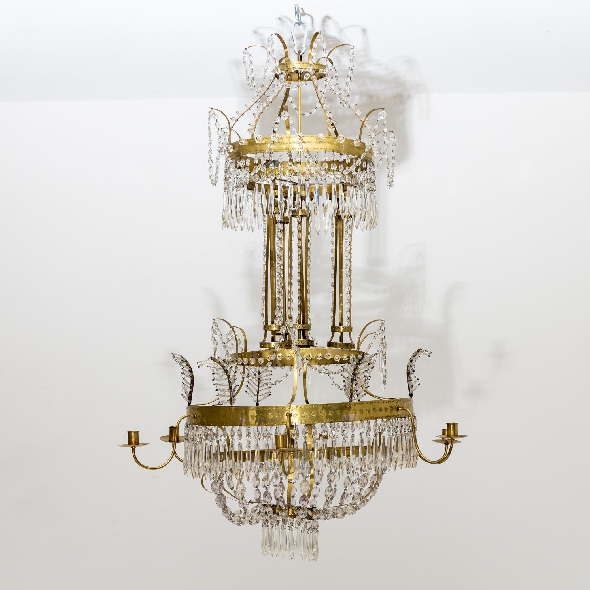 Large brass ceiling chandelier with rich crystal hangings and six arms with candle grommets.
