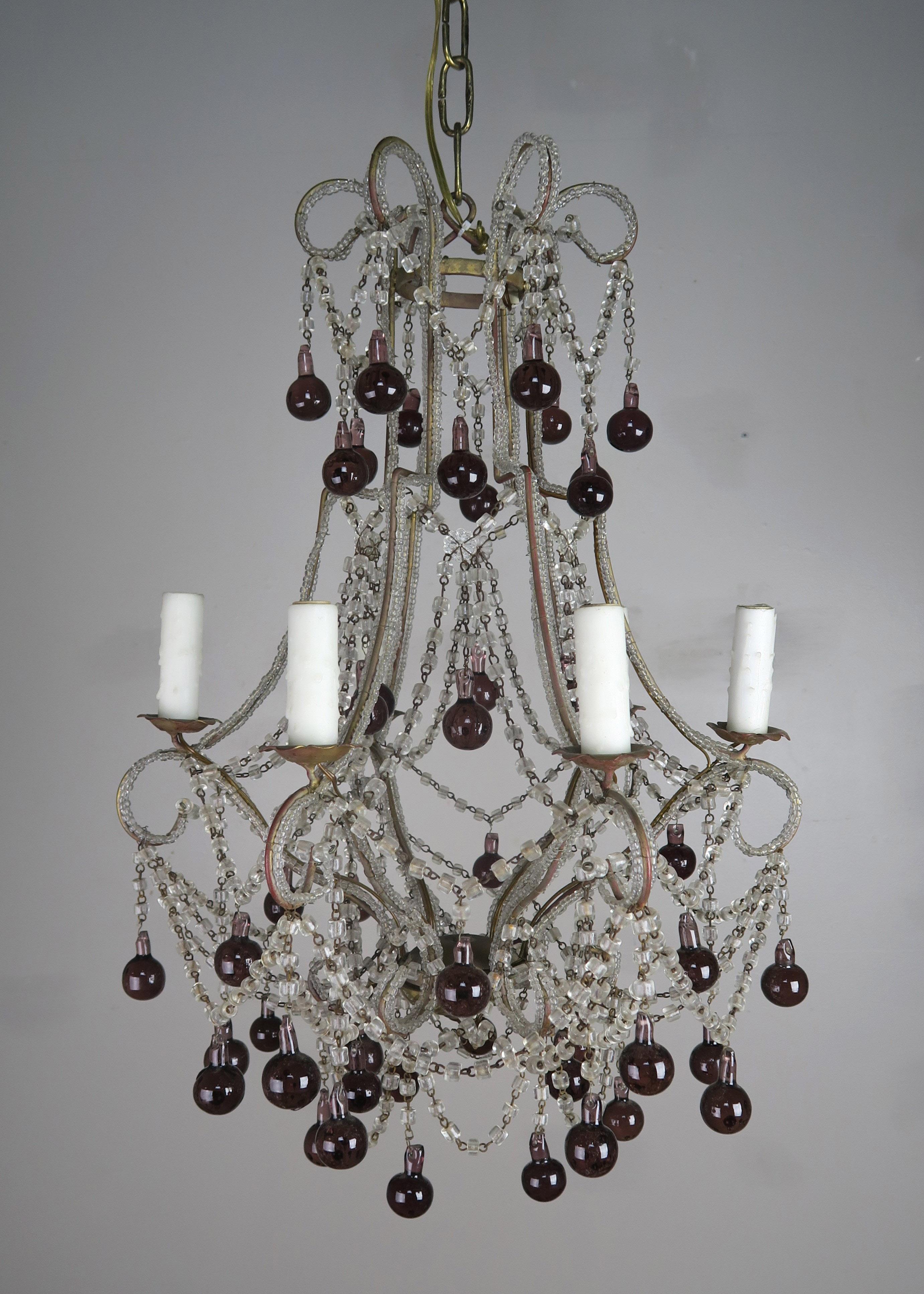 Crystal beaded frame macaroni chandelier adorned with aubergine colored drops throughout. The fixture is newly rewired with drip wax candle covers. Includes chain and canopy.