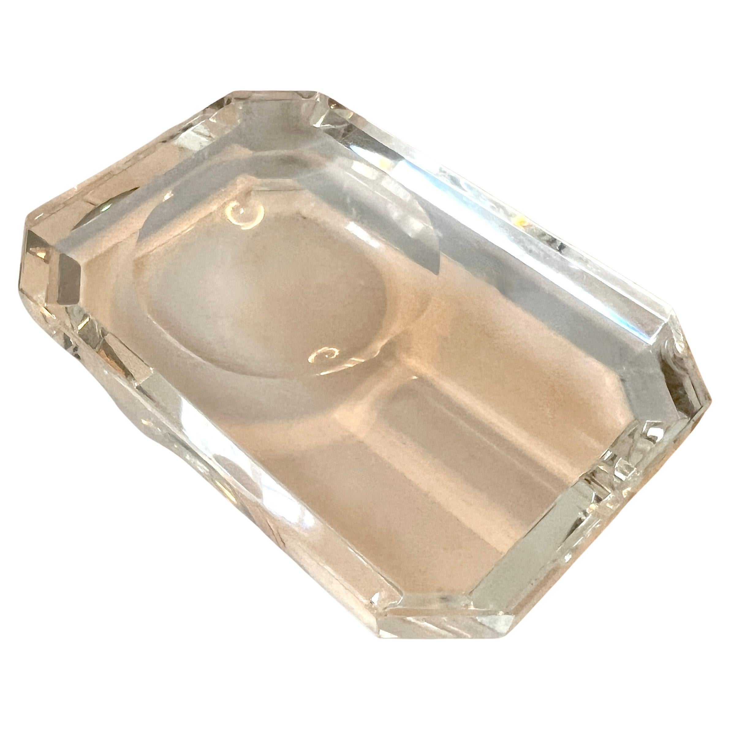 A beautiful crystal cigar ashtray.  The piece is a well crafted block of crystal with hand honed curve for your cigar and a concave circle for ashes.

A stunning complement to any table, smoking room.  Modern, sleek, chic and architectural - a