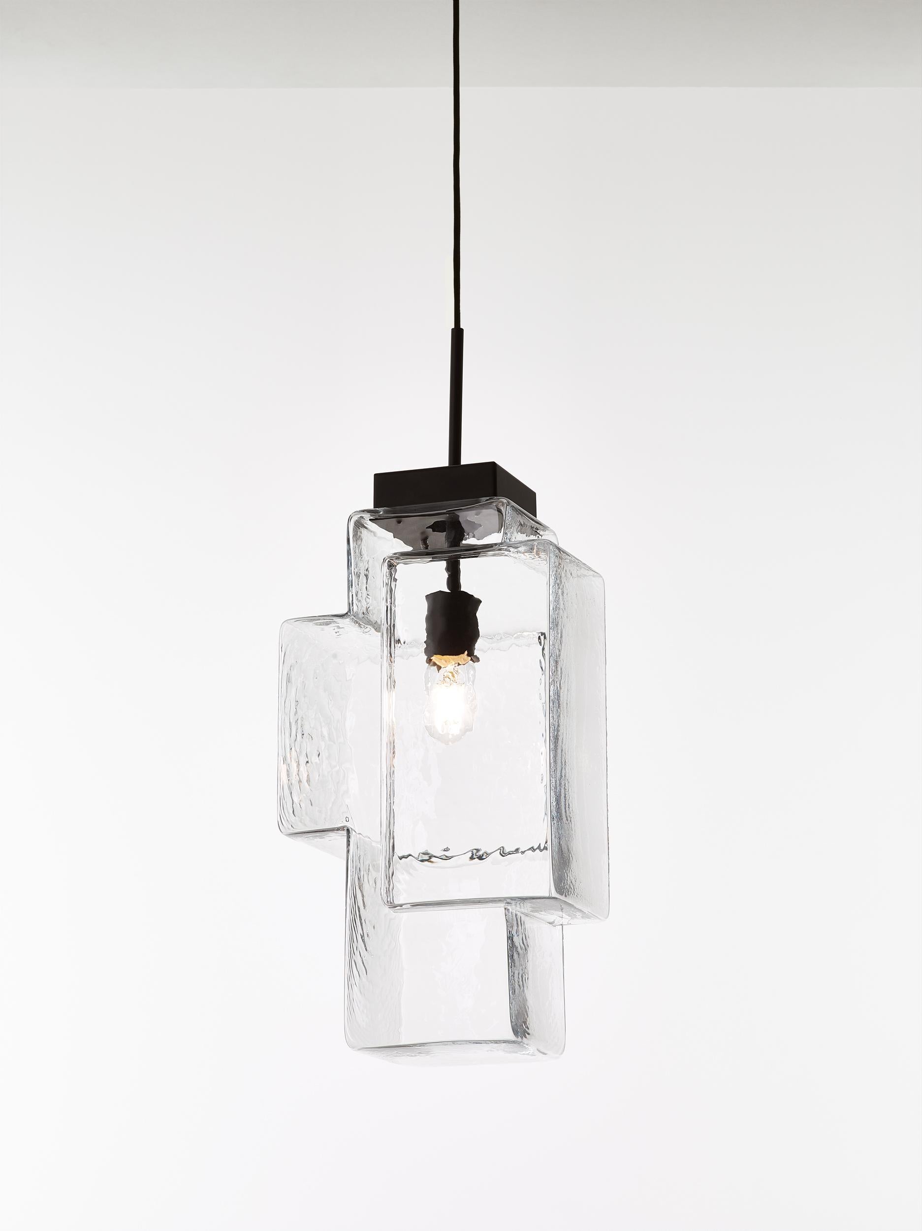 Crystal clear Tetris pendant light by Dechem Studio.
Dimensions: W 30 x D 23 x H 200 cm
Materials: metal, glass.
Also available: different colours available.

In this complex lighting fixture, strict geometric and architectural lines contrast