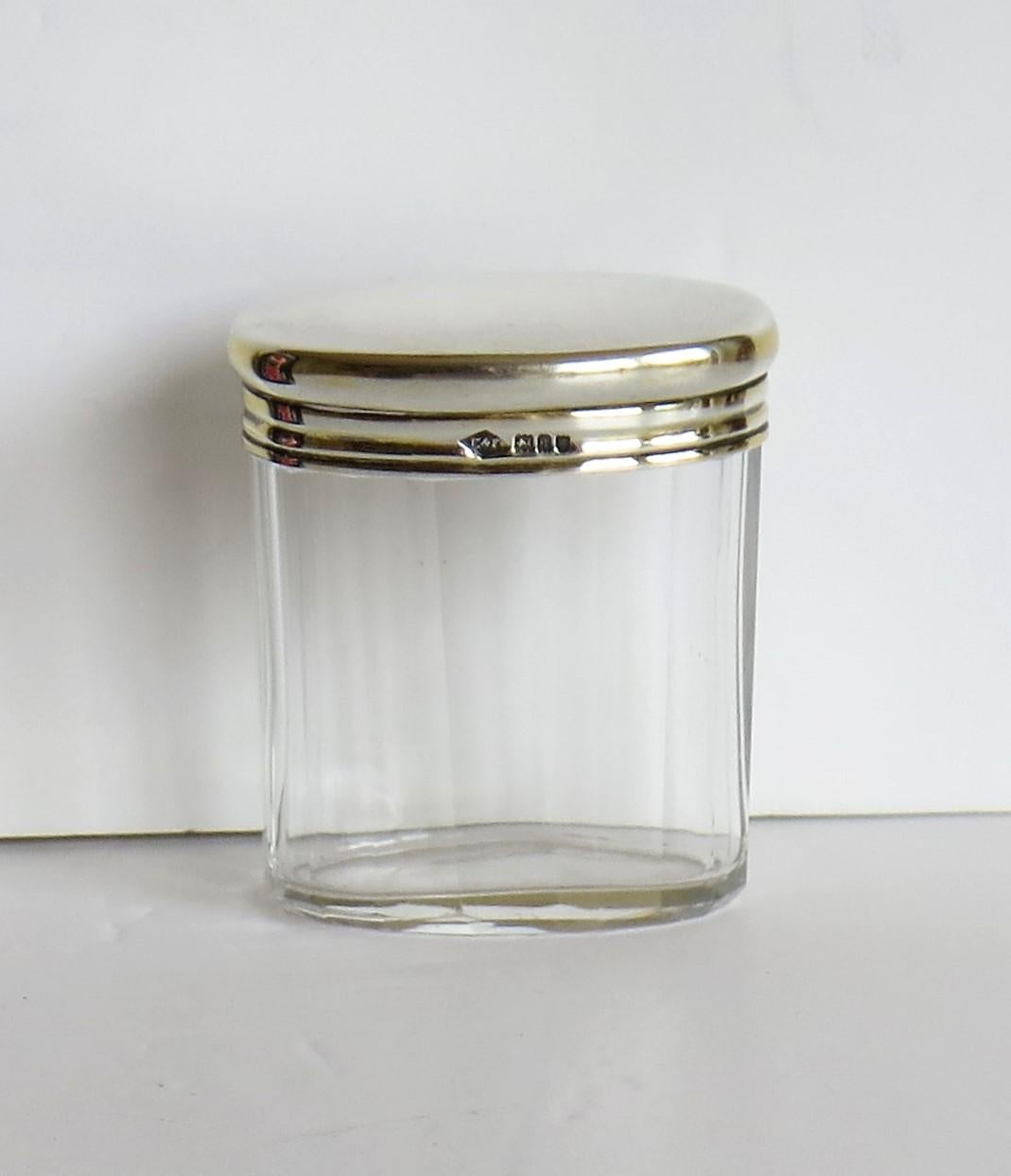 This is a very attractive late Edwardian period crystal cut glass bottle or small Jar with a sterling silver lid, handmade and fully hallmarked by Edward & Sons, Regent Street, London, 1911.

The bottle or jar sits on a small foot and has an oval