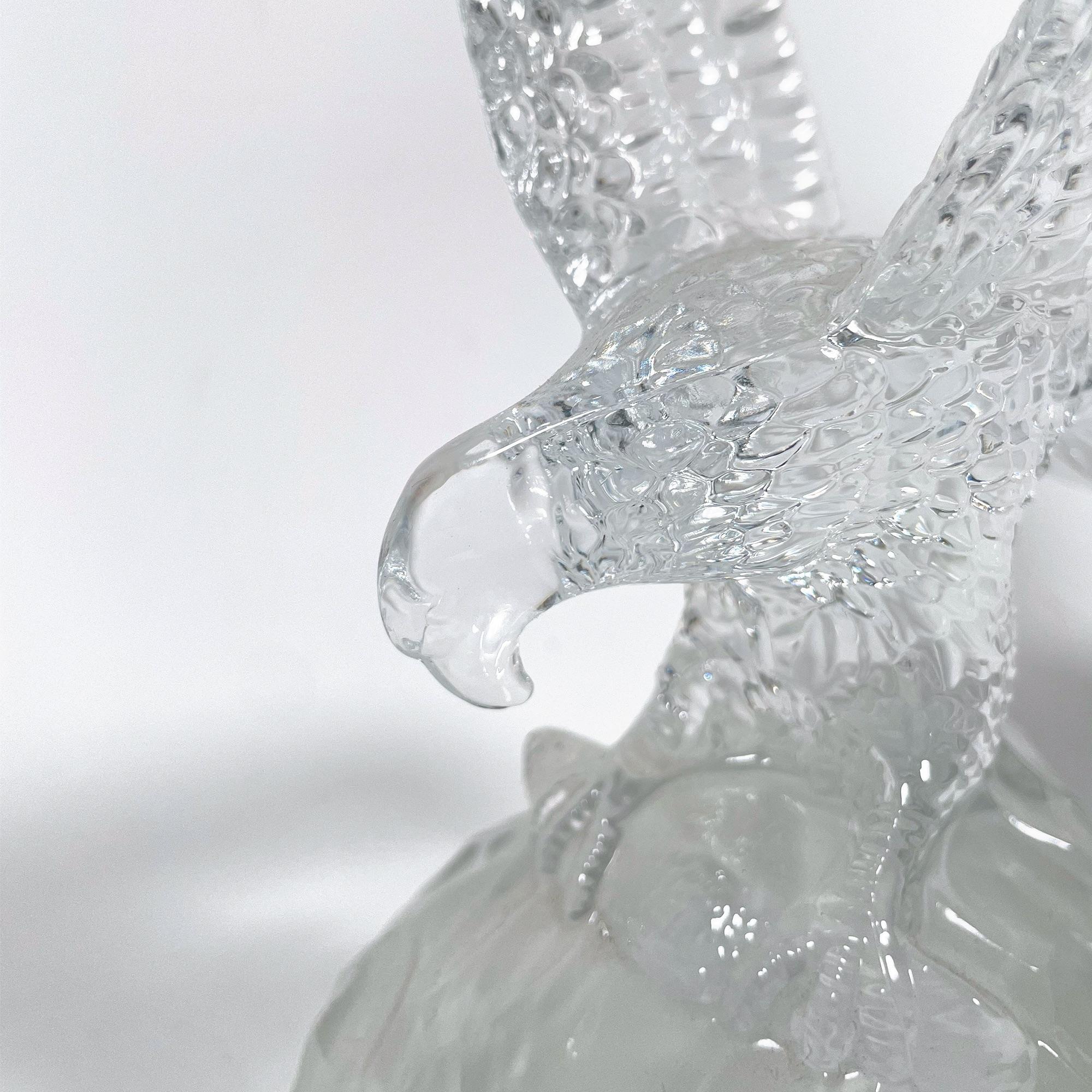 Add a touch of elegance and sophistication to your decor with this stunning crystal eagle sculpture, reminiscent of the iconic Lalique style from the 1980s. This majestic piece, though not signed, exudes the timeless beauty and craftsmanship