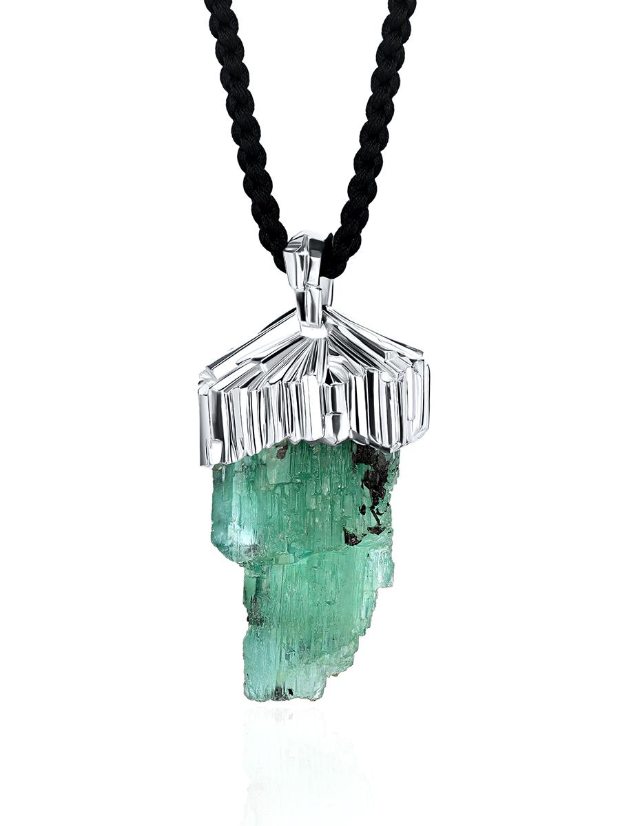 This Raw Crystal Emerald Silver Urals Green Necklace with a Black Silk Cord is a true embodiment of nature's beauty and elegance. The centerpiece of the necklace is a raw emerald crystal, carefully selected for its exquisite shade of green. Unlike