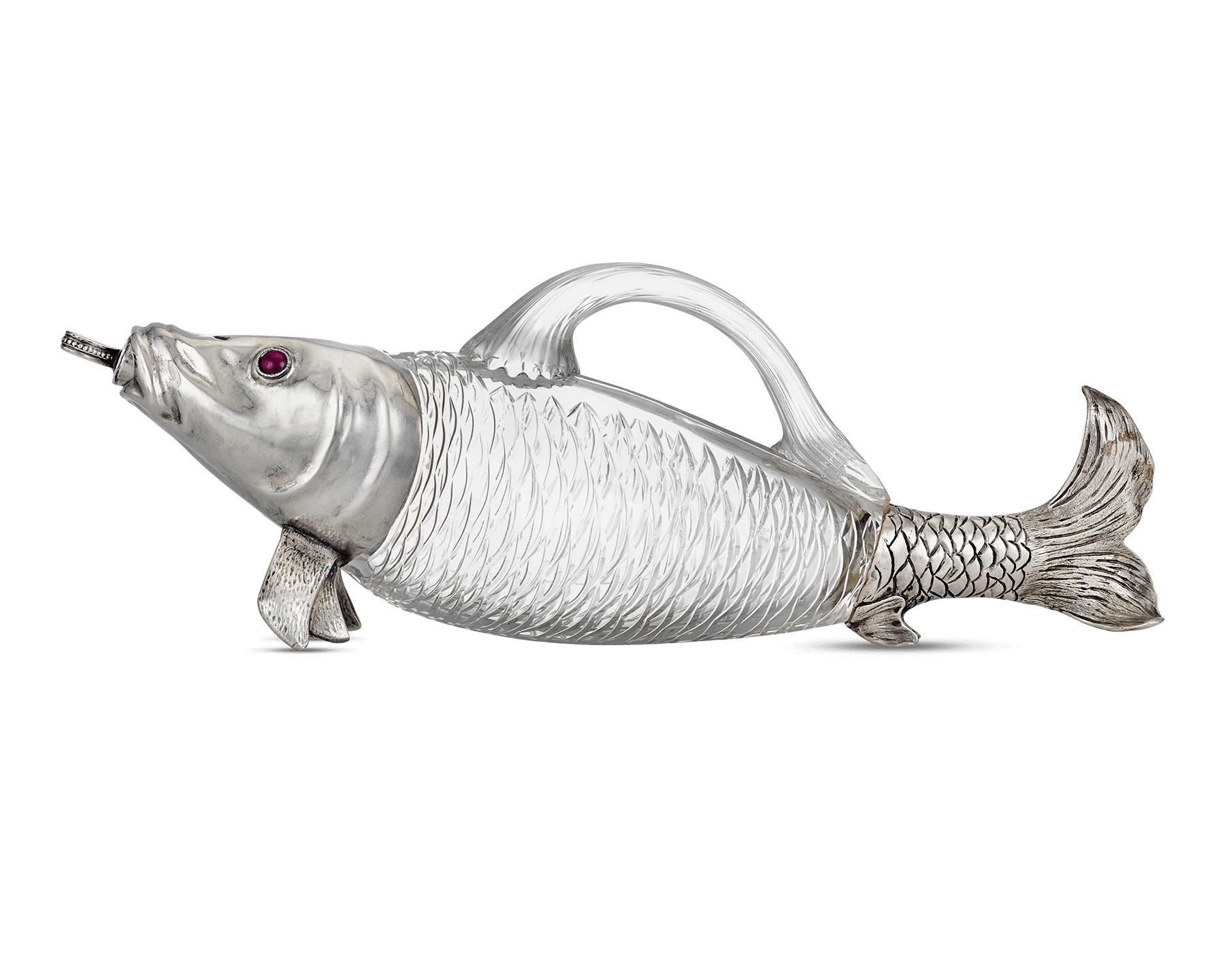 This rare and remarkable claret liquor jug was designed to take the shape of a whimsical fish. Comprised of crystal, the aquatic creature’s body serves as a handled vessel. Its head and tail are crafted of fine silver, including the jug’s spout, the