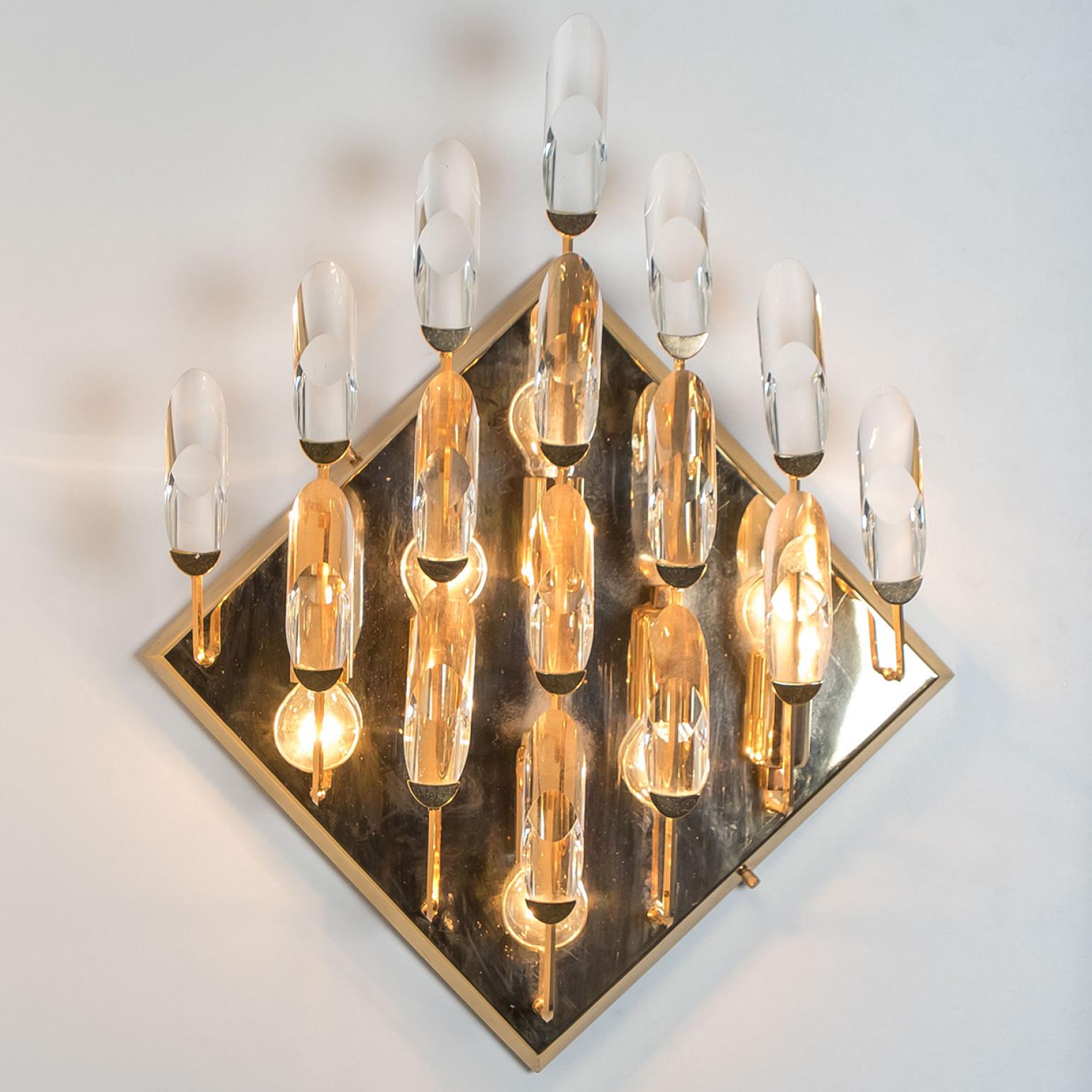 High-end gilded brass wall light by Stilkronen, made in Italy, circa 1975. Each fixture is featuring a weave-like array of branches holding clear crystal droplet-pieces. The crystals refract light beautifully and are perfect for a soft, warm and