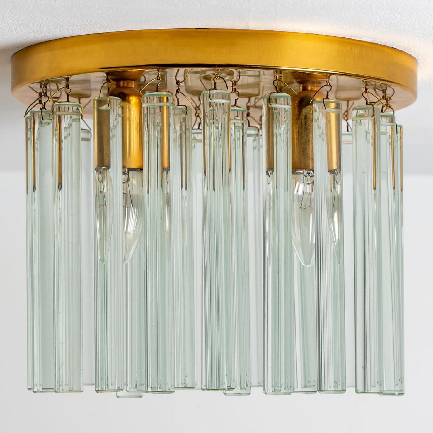 Monture encastrée en laiton et verre de cristal clair de haute qualité, datant du milieu du siècle dernier, par Ernst Palme, Allemagne, années 1970.
L'affleurant a une plaque de plafond en laiton, sur laquelle sont fixés 31 éléments en verre de