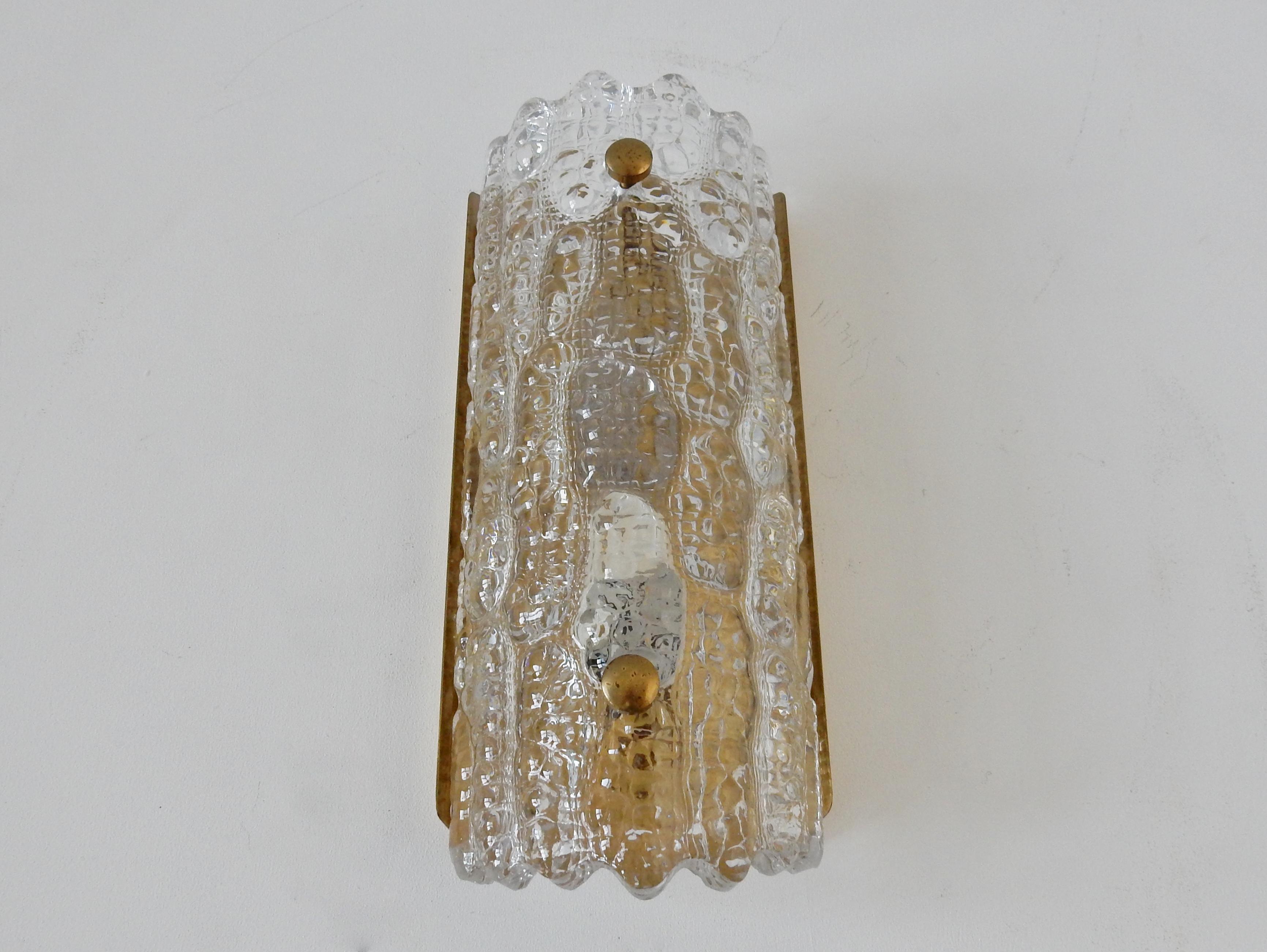 This beautiful and impressive crystal glass and brass 'Gefion' wall sconce was designed by Carl Fagerlund for Orrefors and Lyfa in the 1960s. The sconce is made of thick crystal glass and held in place by two brass screws on a brass fixture. When