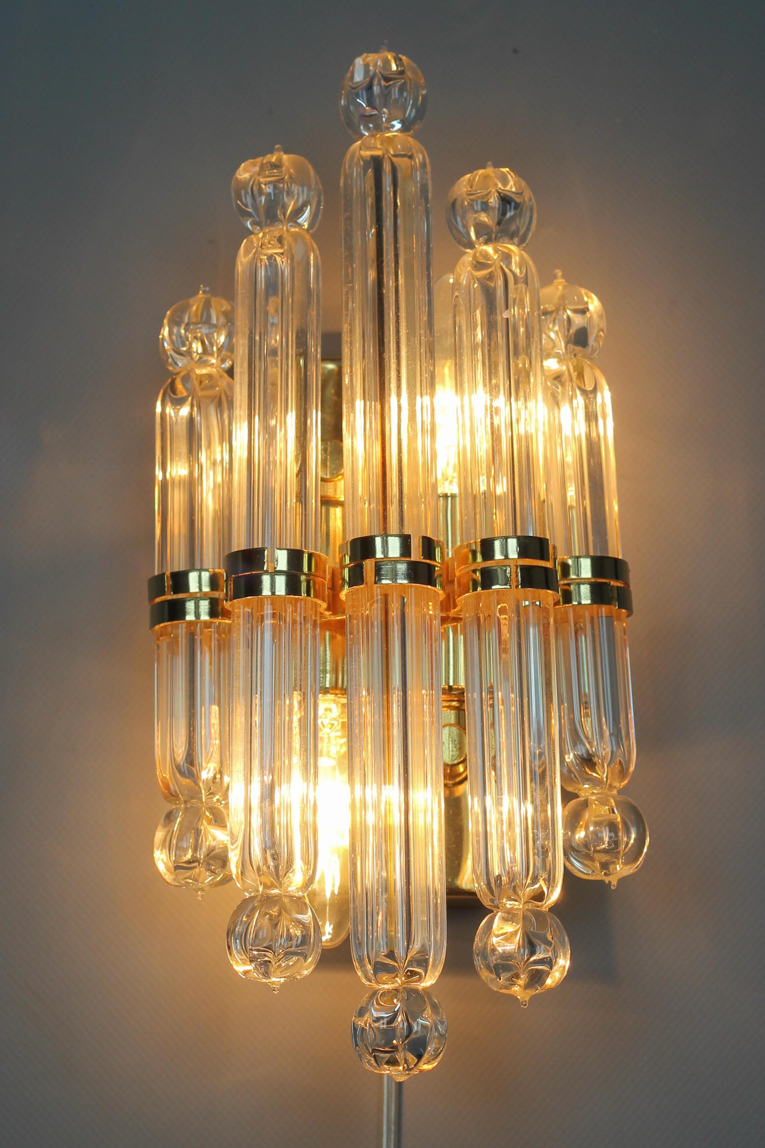 Crystal glass and brass wall lamp by Honsel, Germany, 1980s
This beautiful Art Deco-style two-light wall lamp from the late 20th century features five crystal glass tubes- rods fastened on a brass frame. 
Two sockets for E14 size light bulbs.
In