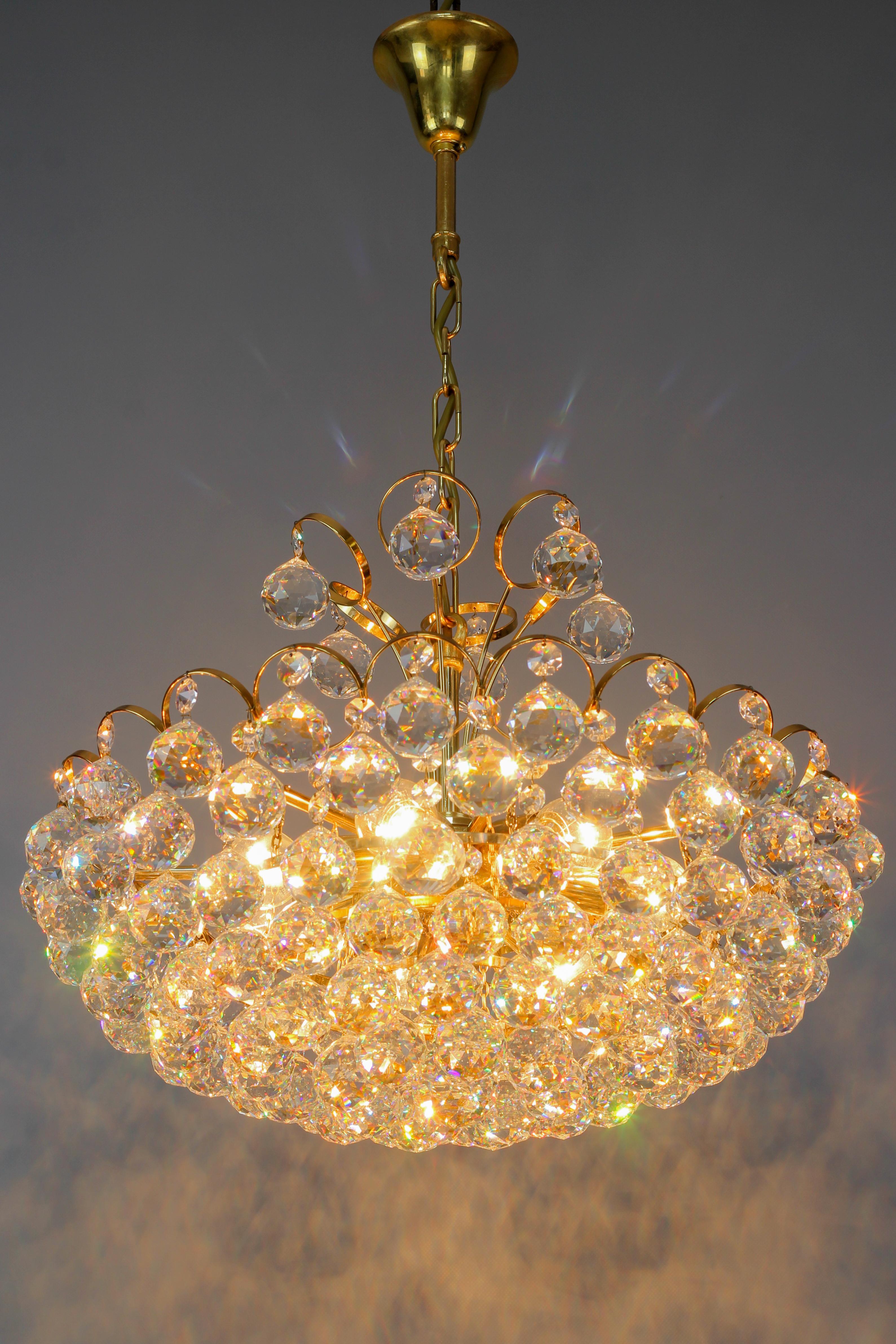 Crystal Glass and Gilt Brass Seven-Light Chandelier, made in Germany, in the late 1970s, is attributed to Christoph Palme.
This impressive and highly decorative piece features a gilt brass frame gracefully decorated with cut crystal glass spheres.