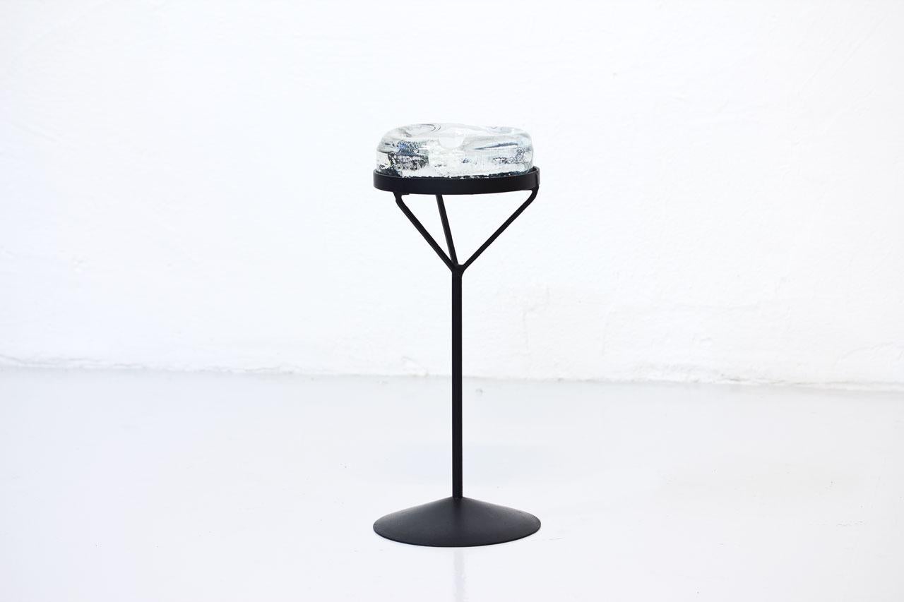 Crystal glass ashtray with iron stand featuring female breast expression. 
Designed by Erik Höglund.
Manufactured by Boda in Sweden during the 1950s.