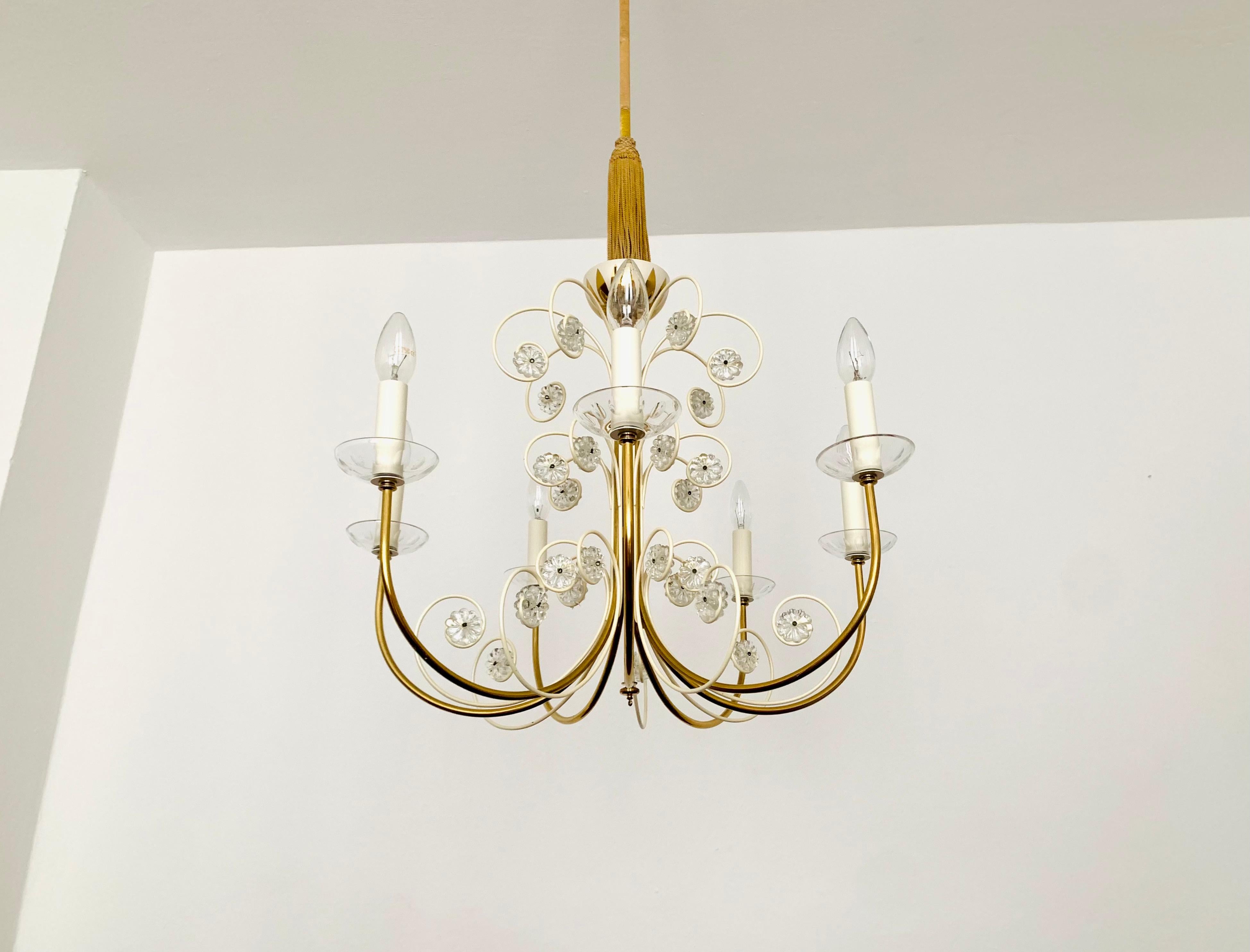 Extremely beautiful chandelier from the 1950s.
The high-quality workmanship and the very noble material impress at first sight.
Exceptionally beautiful design.
The sparkling stones spread a sensational light.

Manufacturer: Vereinigte