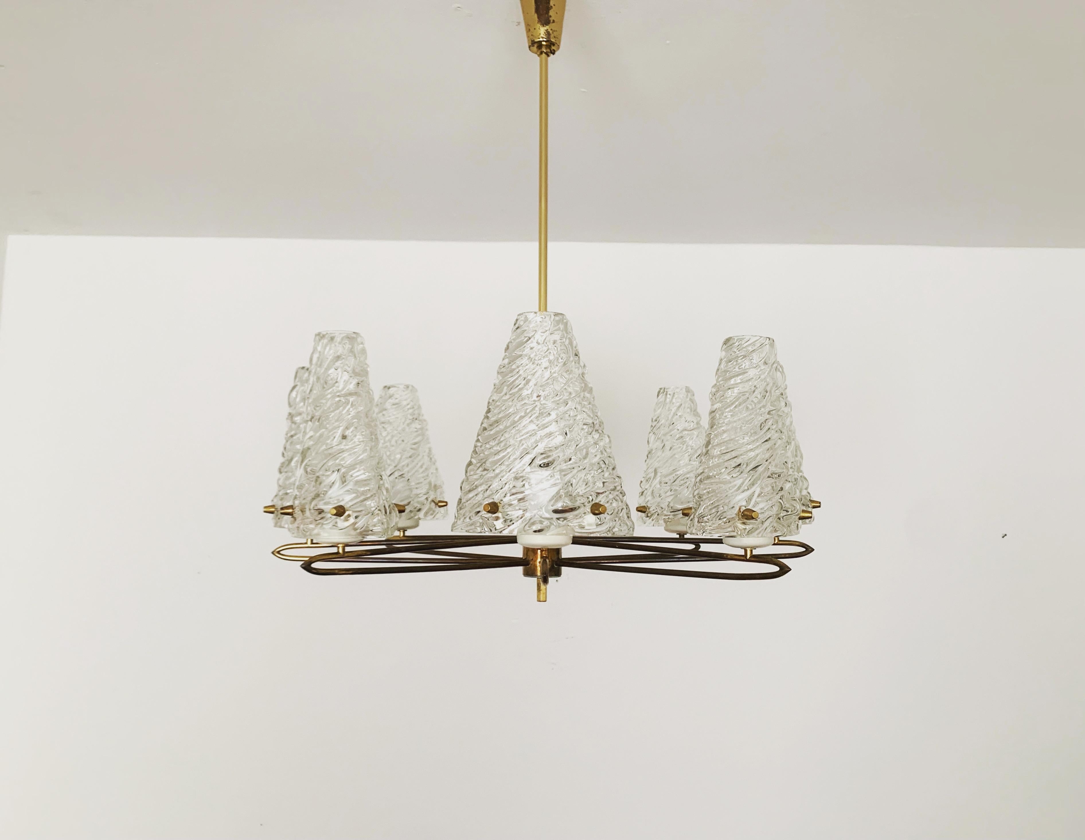 Bellissimo lampadario in cristallo degli anni '50.
Meraviglioso bicchiere soffiato in bocca con una grande struttura.
La cornice in ottone filigranato sottolinea l'aspetto nobile.
Il design e i materiali utilizzati creano una luce scintillante.
Un