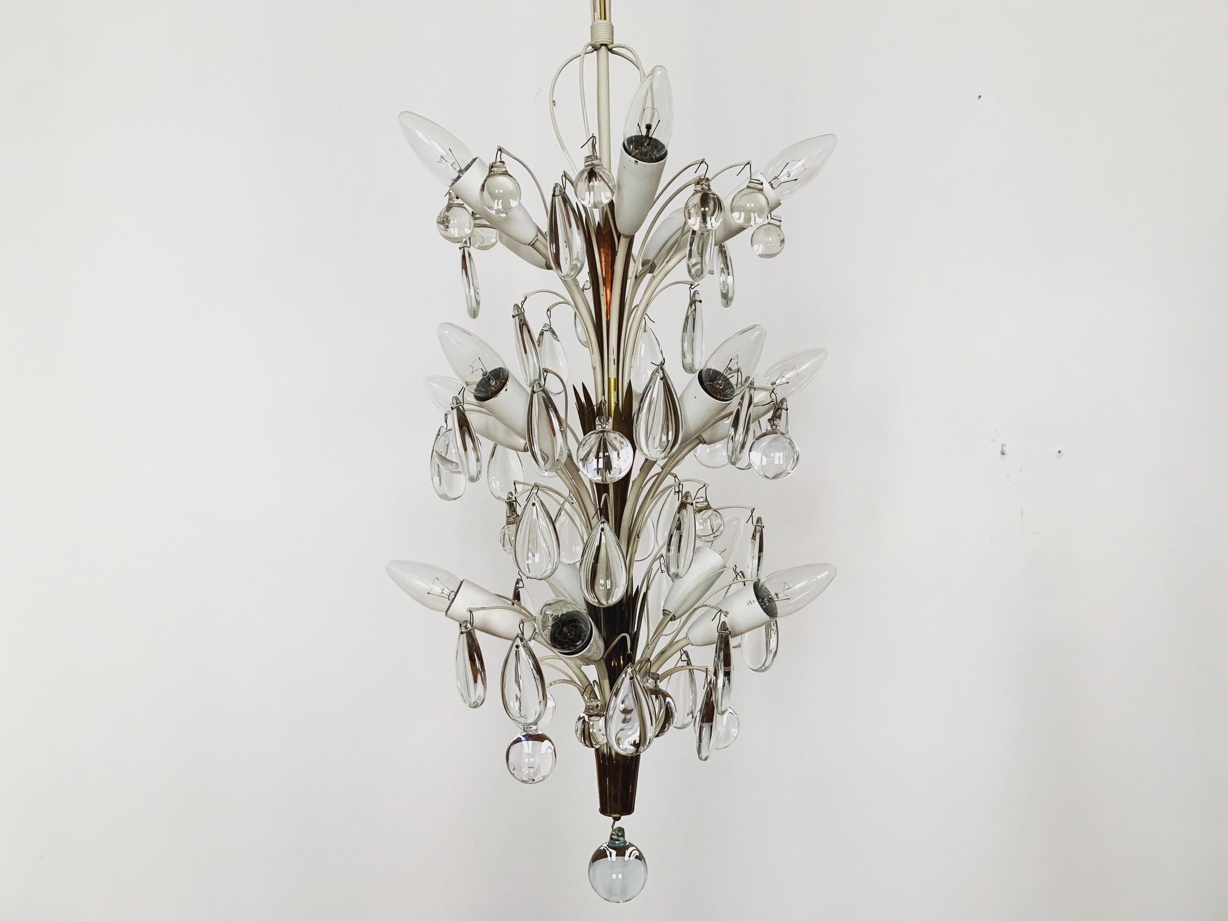 Extremely beautiful chandelier from the 1950s.
The high-quality workmanship and the very noble material impress at first sight.
Exceptionally beautiful design.
The sparkling stones spread a sensational light.

Manufacturer: Vereinigte Werkstätten