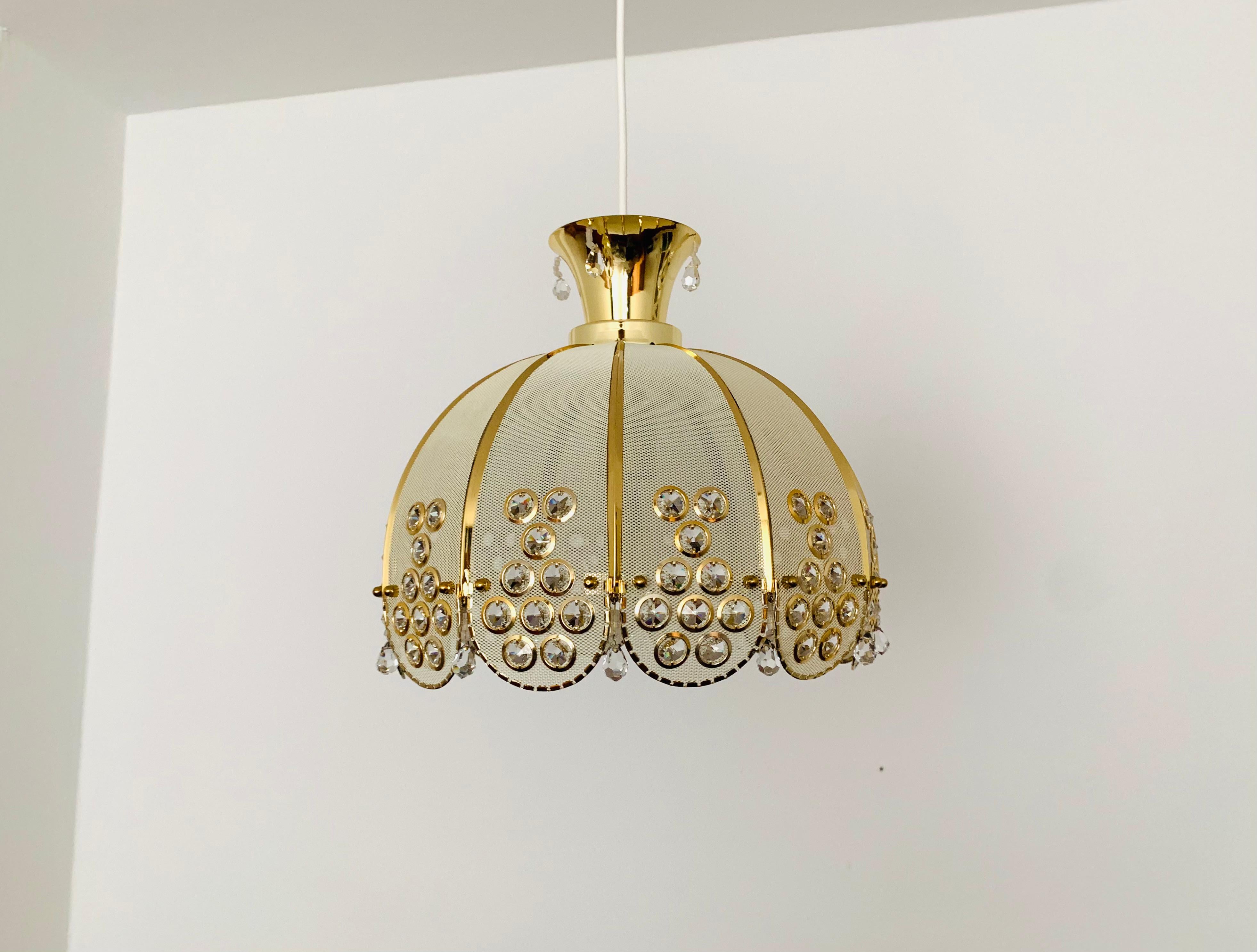 Lampada a sospensione di grande bellezza e qualità degli anni '60.
L'eccellente lavorazione e il materiale molto nobile colpiscono al primo sguardo.
Un design eccezionalmente bello.
La lampada diffonde uno spettacolare gioco di luci nella