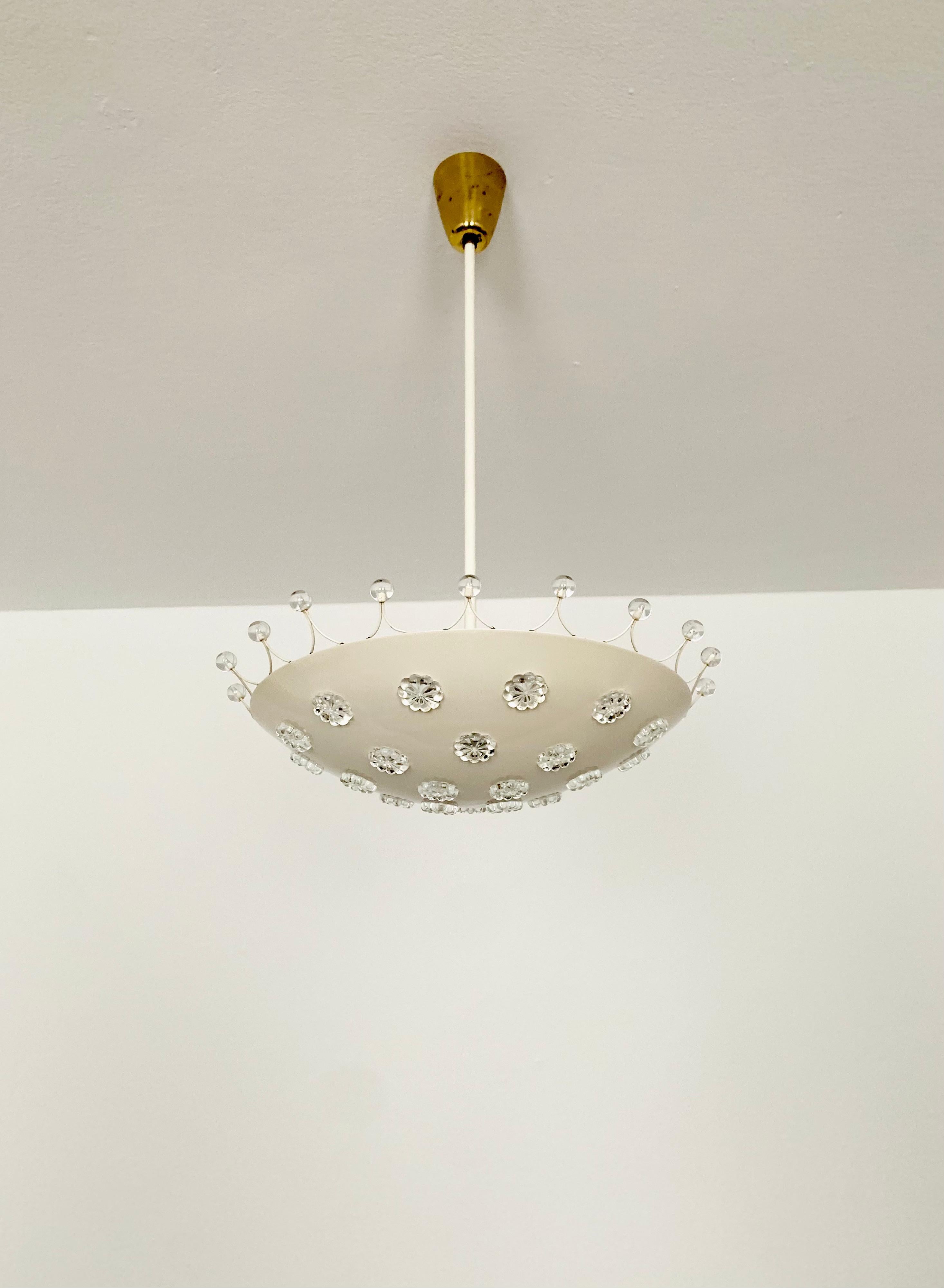 Wonderful ceiling lamp from the 1950s.
The lamp with the crystal glass flowers has a very luxurious look and sparkles particularly beautifully.
The design and the materials used create a great glittering light.
A stunning lamp and a real addition to