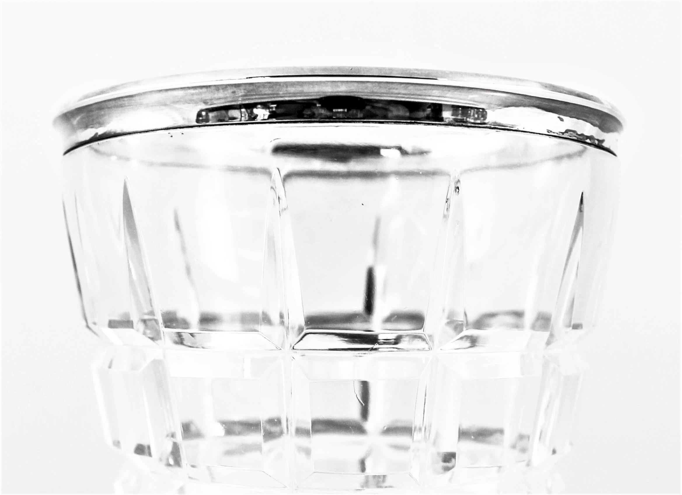 This crystal ice bucket has a sterling silver rim around the top. The crystal is cut into squares giving it an Art Deco design. It has a modern look while maintaining its original Art Deco style. Great for a bar or dinner table, you always need ice.