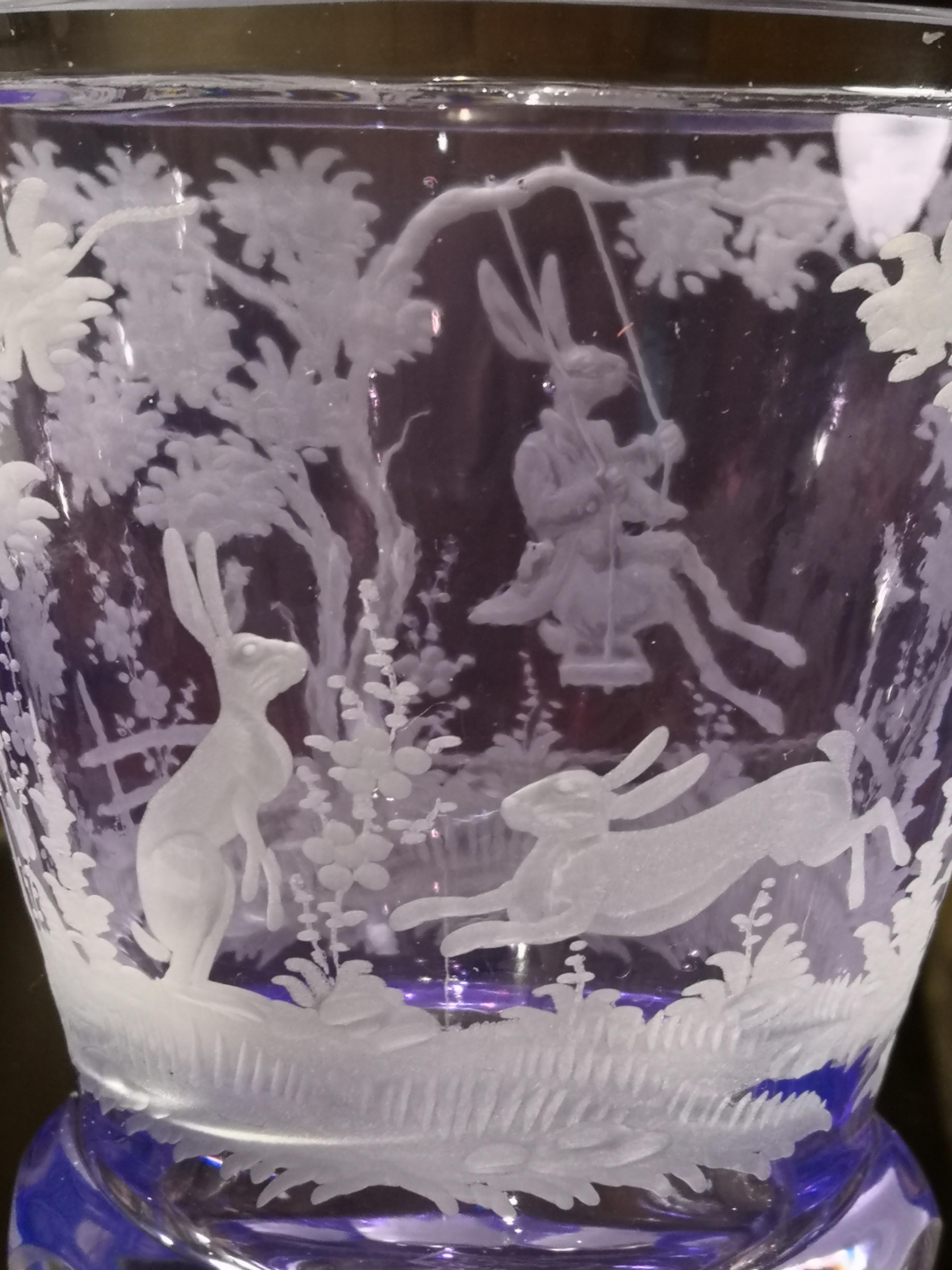 Hand blown crystal vase/latern in purple glass with an antique country style Easter decor all-around. The country style decor shows bunnies and trees all-around. The glass comes in purple color and can be ordered in different colors. Completely