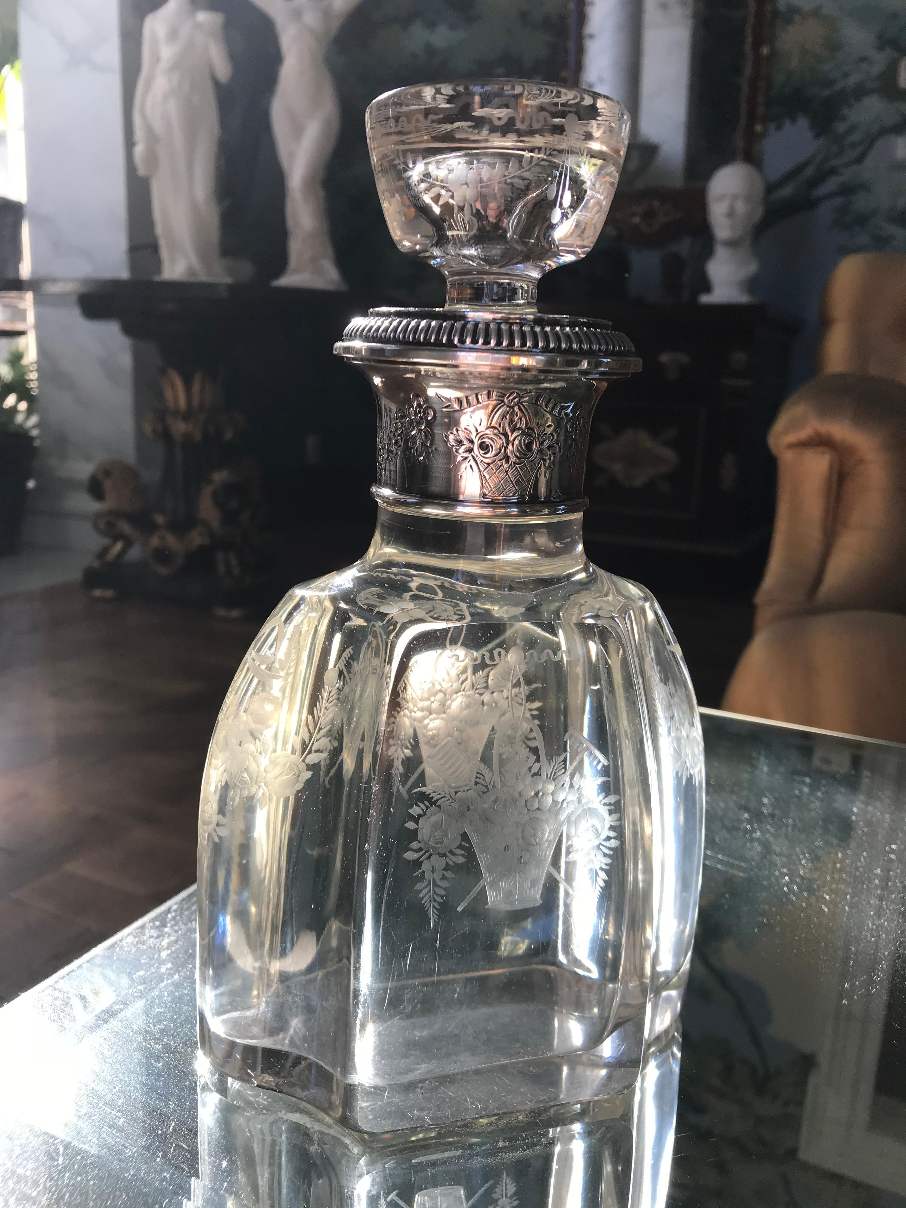 Exquisite French hand blown crystal bottle with finely detailed etching of fruit and flower baskets. It retains it's original lid and sterling collar with embossed rose swags.