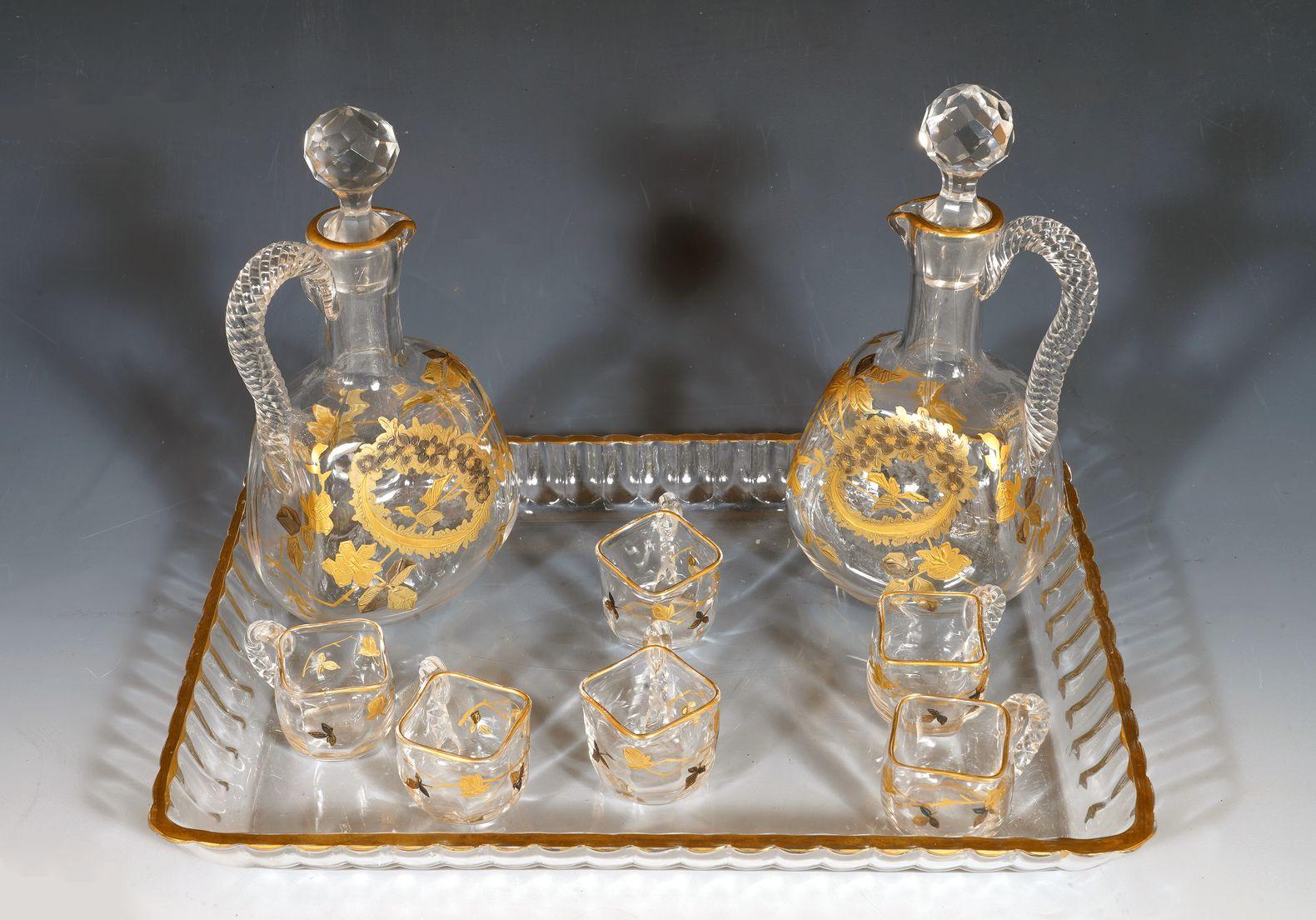 Vassoio - Lunghezza : 29 cm (11,4 in.) ; Larghezza : 21 cm (8,3 in.)
Caraffa - Altezza: 19 cm (7,5 in.)

Incantevole servizio di liquori in cristallo decorato con fogliame dorato composto da due caraffe con relativi tappi e sei coppette, tutte con