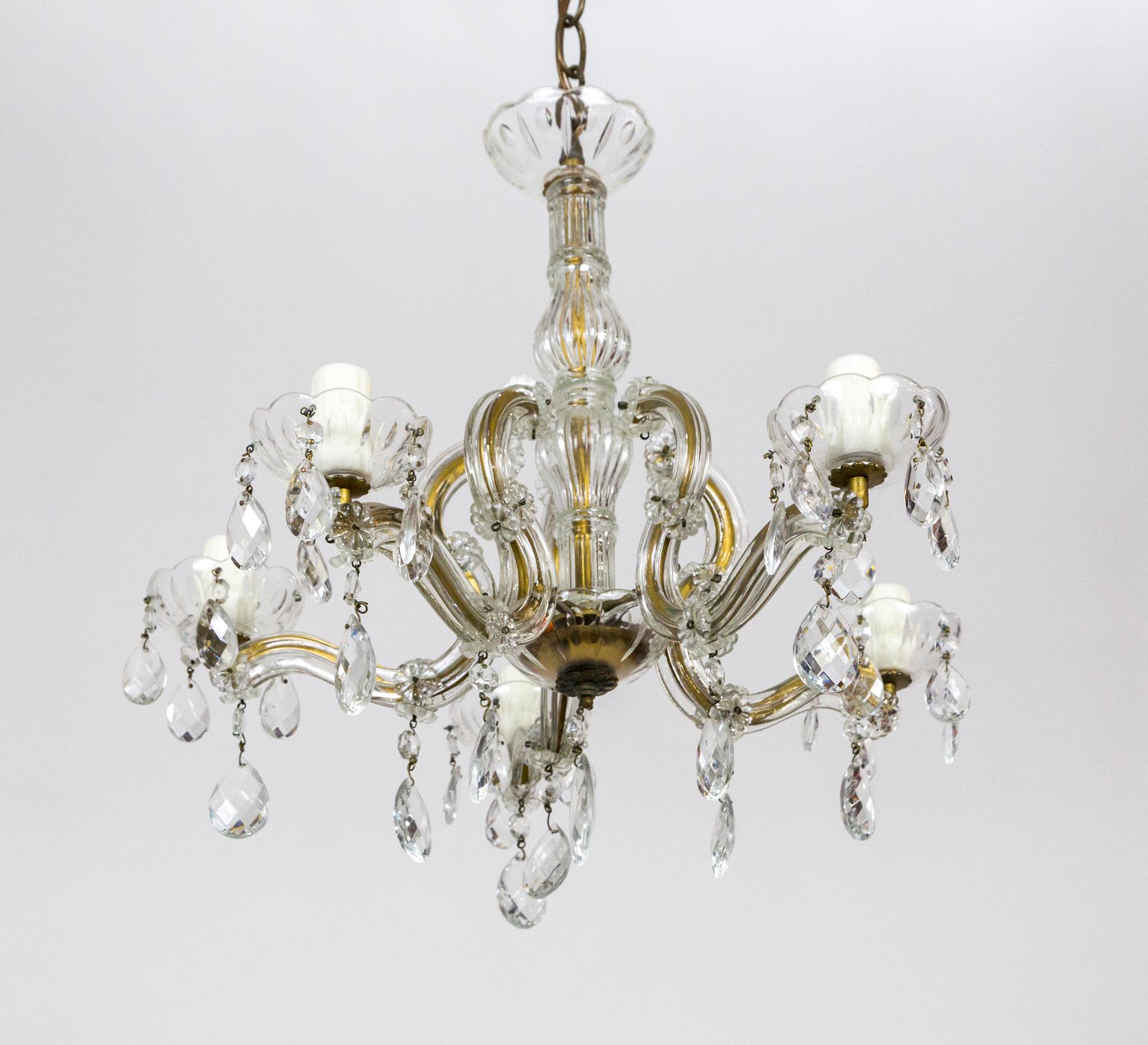 A modestly sized, 5-light chandelier in the Austrian, Maria Theresa style - a brass structure covered with crystal, molded glass. It has dangling cut almond crystals, rosette crystals adorning the arms, and new, poly-beeswax candle covers. New chain