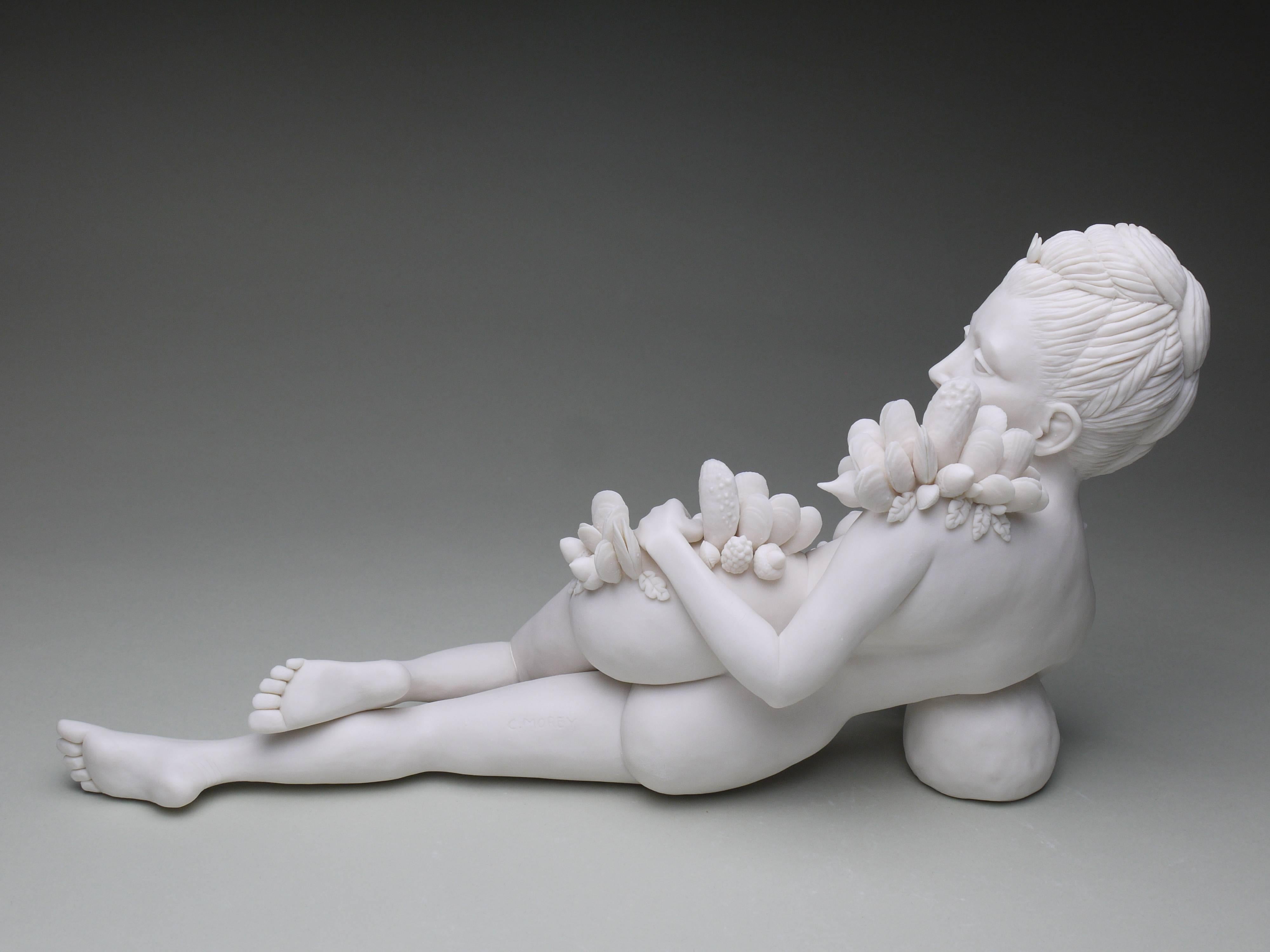 This is a nude, figurative sculpture. It is reference to the Greek goddess of the hunt: Diana. She is recumbent in the sculpture, and looking over her shoulder at the viewer. Mussel shells grow over her hips, shoulders, and arms. This piece is made