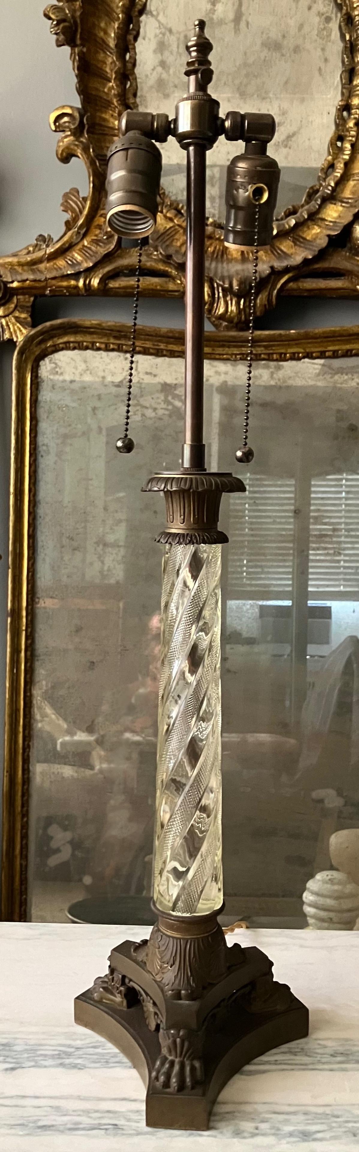 Crystal Neoclassical style column lamp. Vintage bronze and crystal two-light lamp in roman empire classical style consisting of serpentine form crystal fluted shaft with acanthus banded capital supporting a foliate triform base on paw feet and