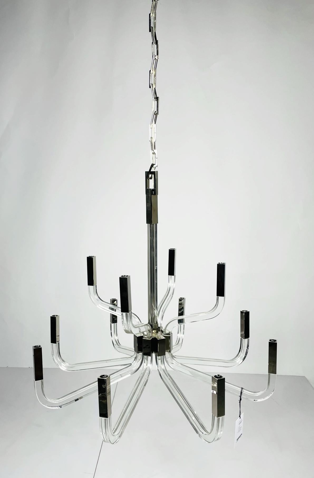 The Reagan chandelier from visual comfort signature, formerly known as Visual Comfort, is a sweeping modern construction of crystal and steel. A Chapman & Myers design descending from a square ceiling mount via a rectangular-linked chain, the