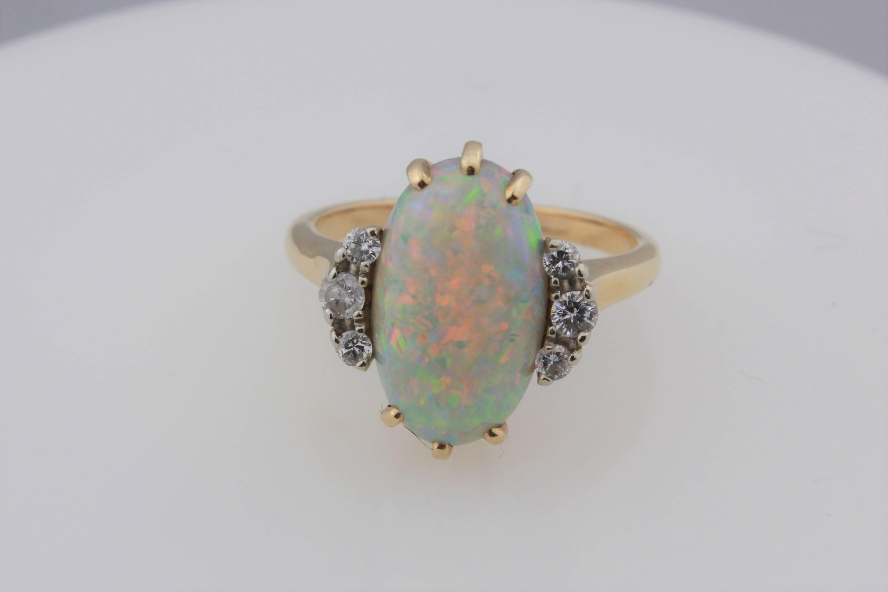 Crystal Opal and Diamond Ring Set in 14kt Yellow Gold.  The crystal opal has a beautiful reddish orange play of color that is consistent throughout the gem!  The diamonds total approximately .15 carats.  the ring is size 5.5 and is sizeable.