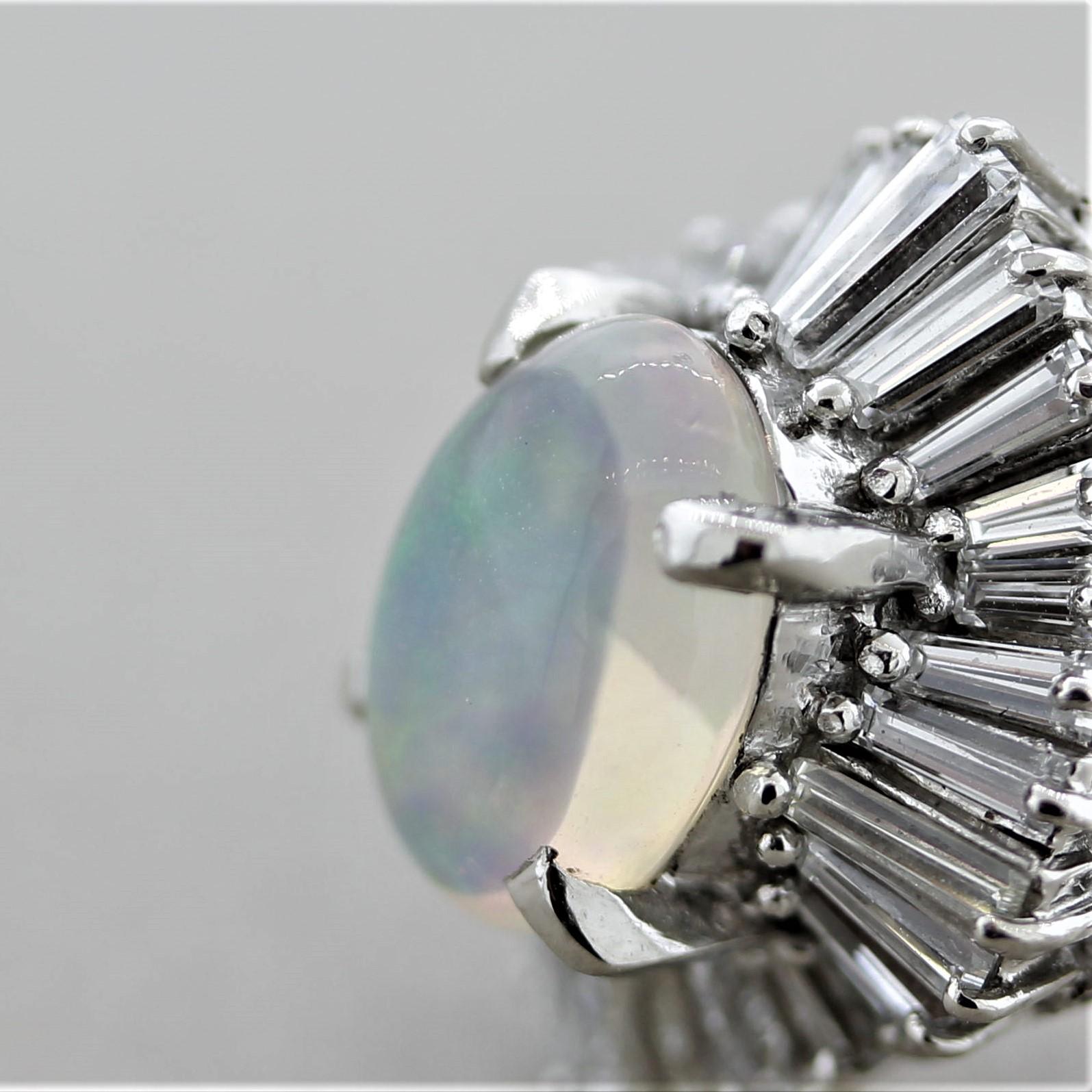 Une bague douce et élégante avec une opale en cristal de 2,13 carats ! Elle présente un grand jeu de couleurs, des éclats de rouge, de vert et de jaune pouvant être vus danser sur la pierre. Elle est rehaussée de 1,43 carats de diamants de taille
